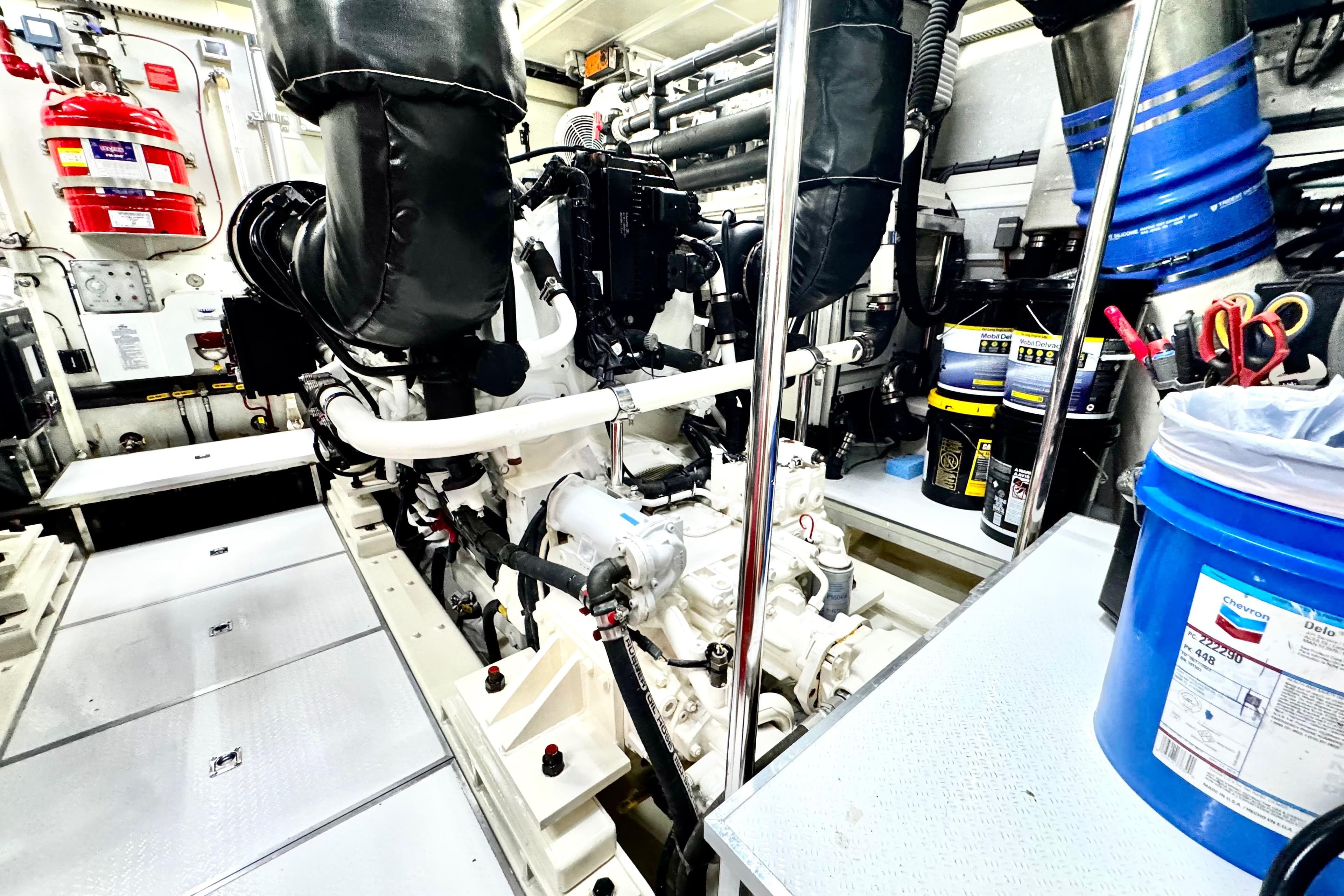 Engine room of 2011 Horizon E88 yacht, featuring machinery and maintenance supplies.