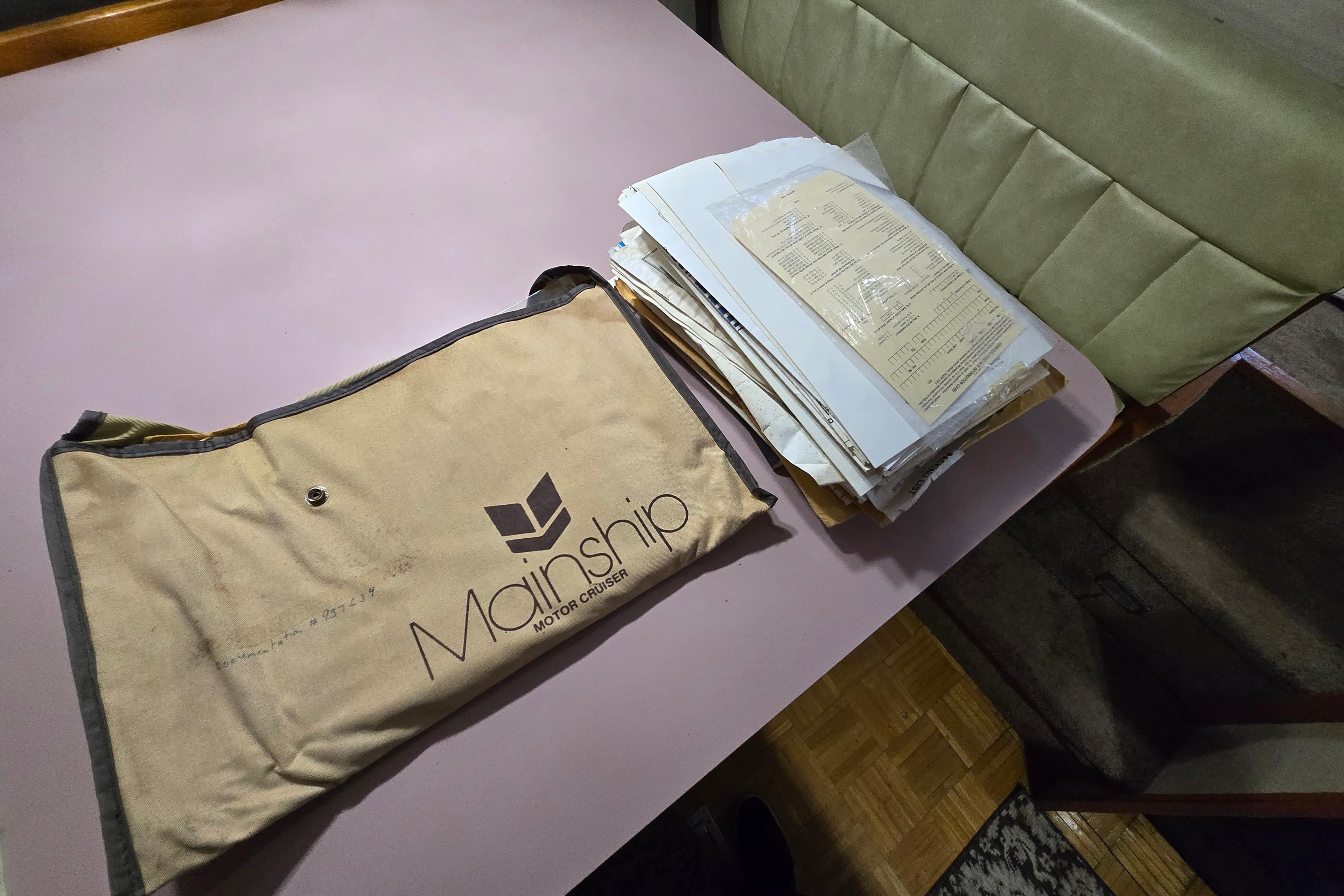 Mainship 36 Double Cabin 1988 documents and manual on a table.