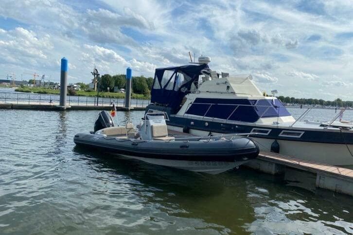 2018 Infanta 7.5 SR boat docked beside a larger yacht on a sunny day.