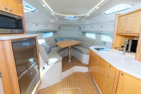 Luxurious interior of 2023 Intrepid 438 Evolution yacht with modern kitchen and seating area.