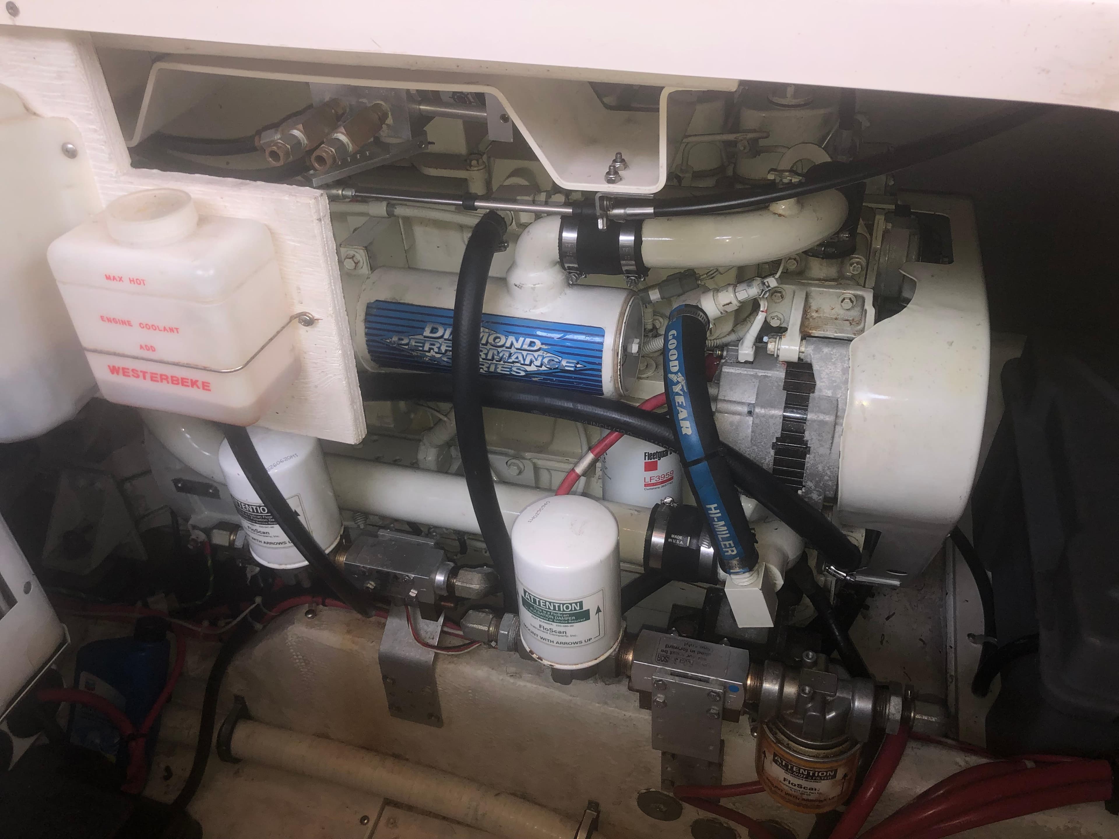 Engine compartment of a 2001 Maxum 4100 SCA boat, featuring mechanical components and hoses.