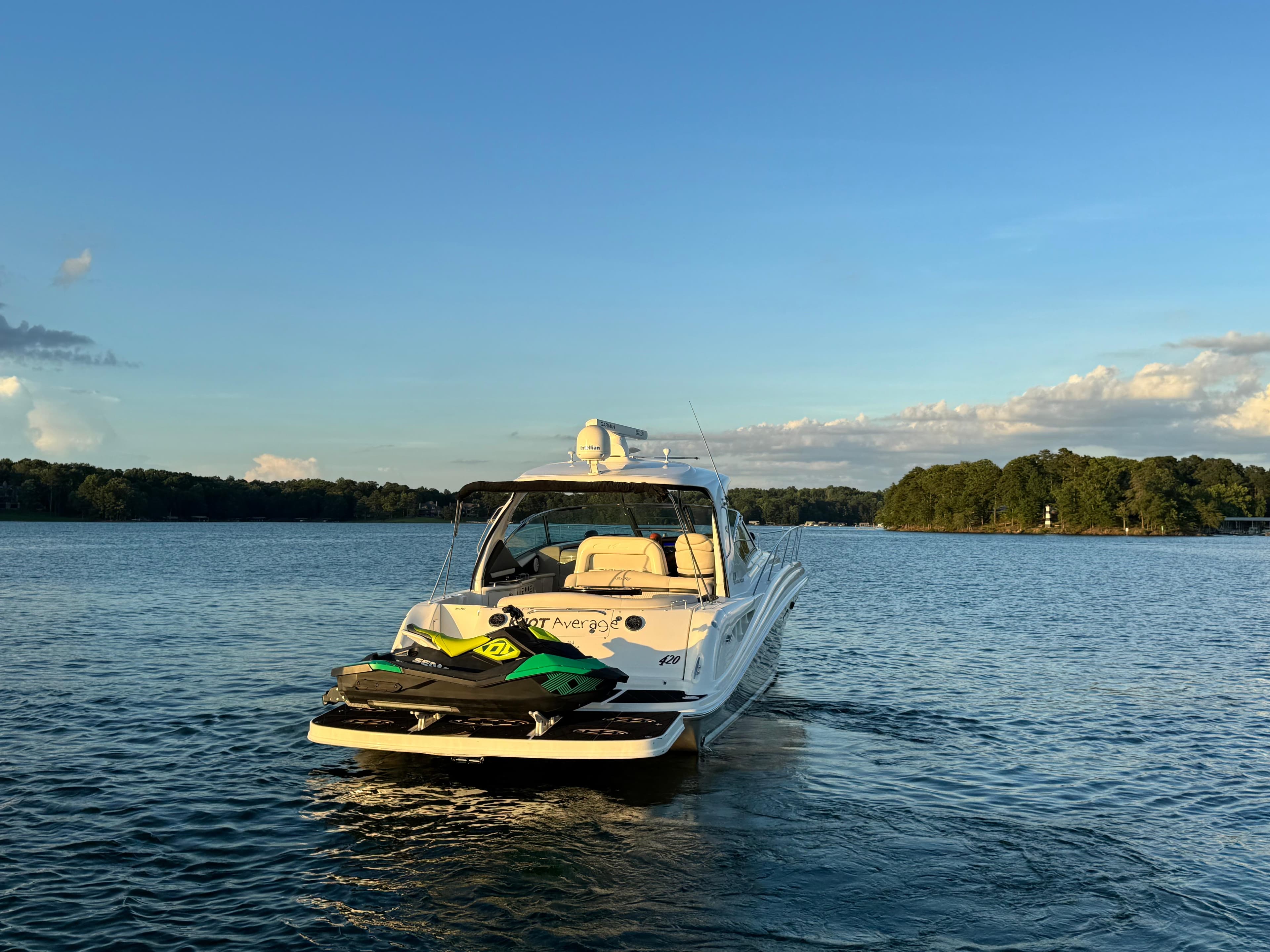 2005 Sea Ray 420 Sundancer yacht on a serene lake at sunset.