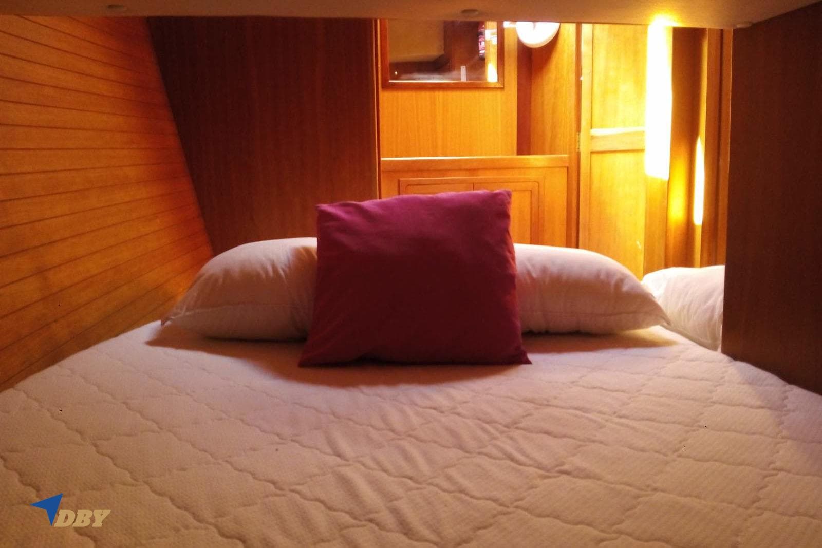 Cozy cabin interior of 2006 Dudley Dix 43 sailboat with wooden finish and comfortable bedding.