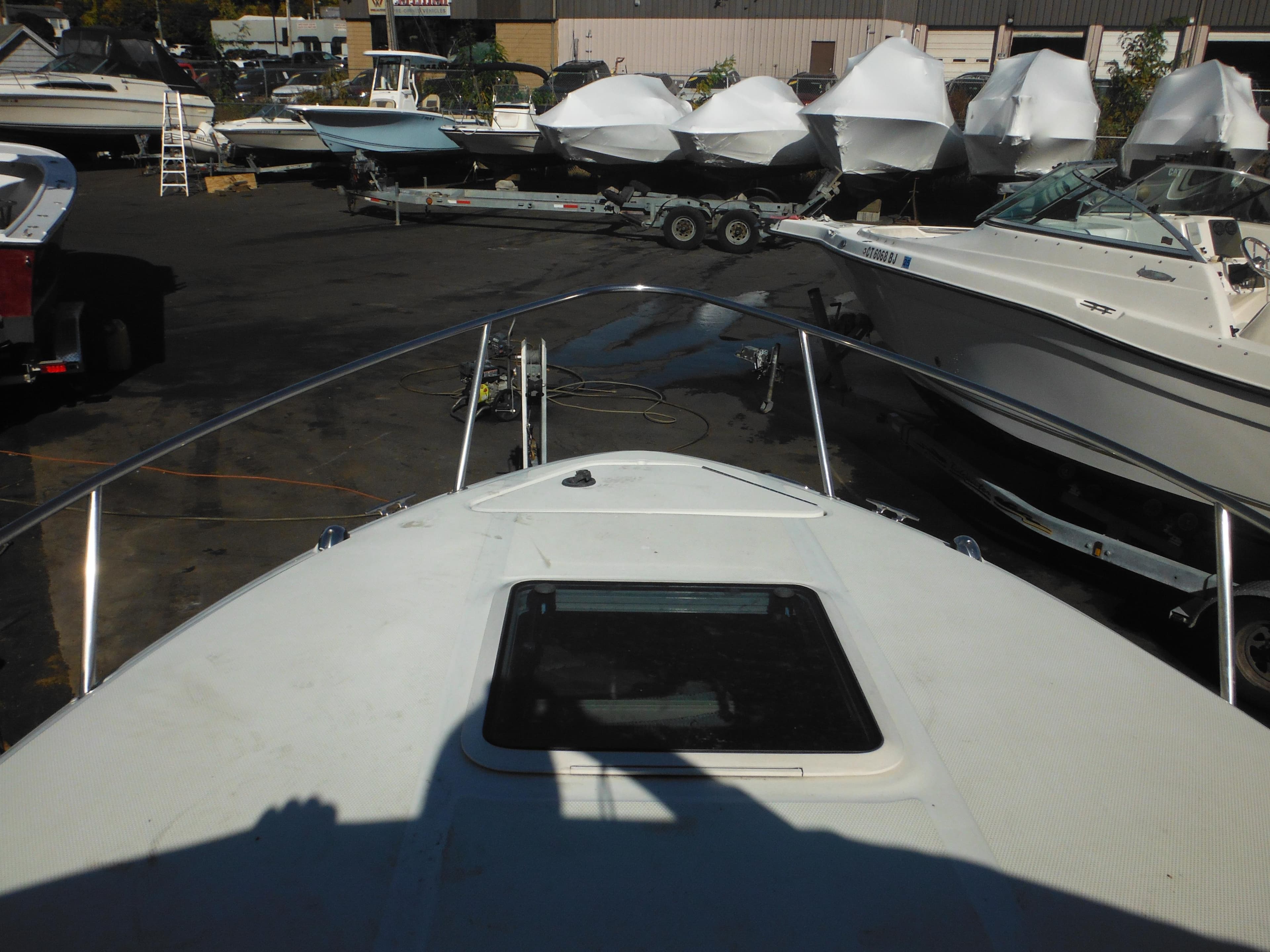 2004 Sea Ray 215 Weekender boat in marina, surrounded by other vessels.
