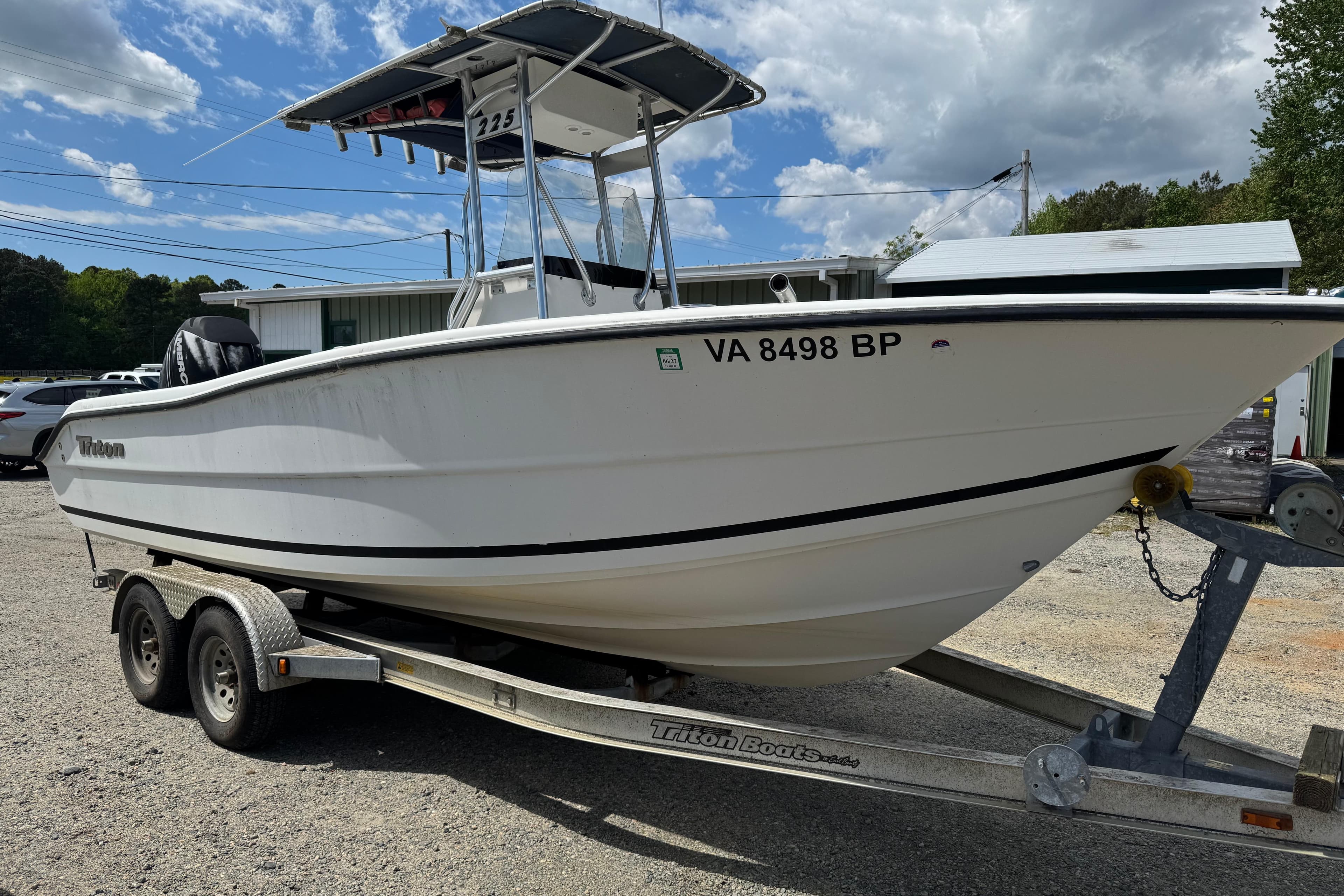 2008 Triton 225 CC boat on trailer, parked outdoors under a partly cloudy sky.