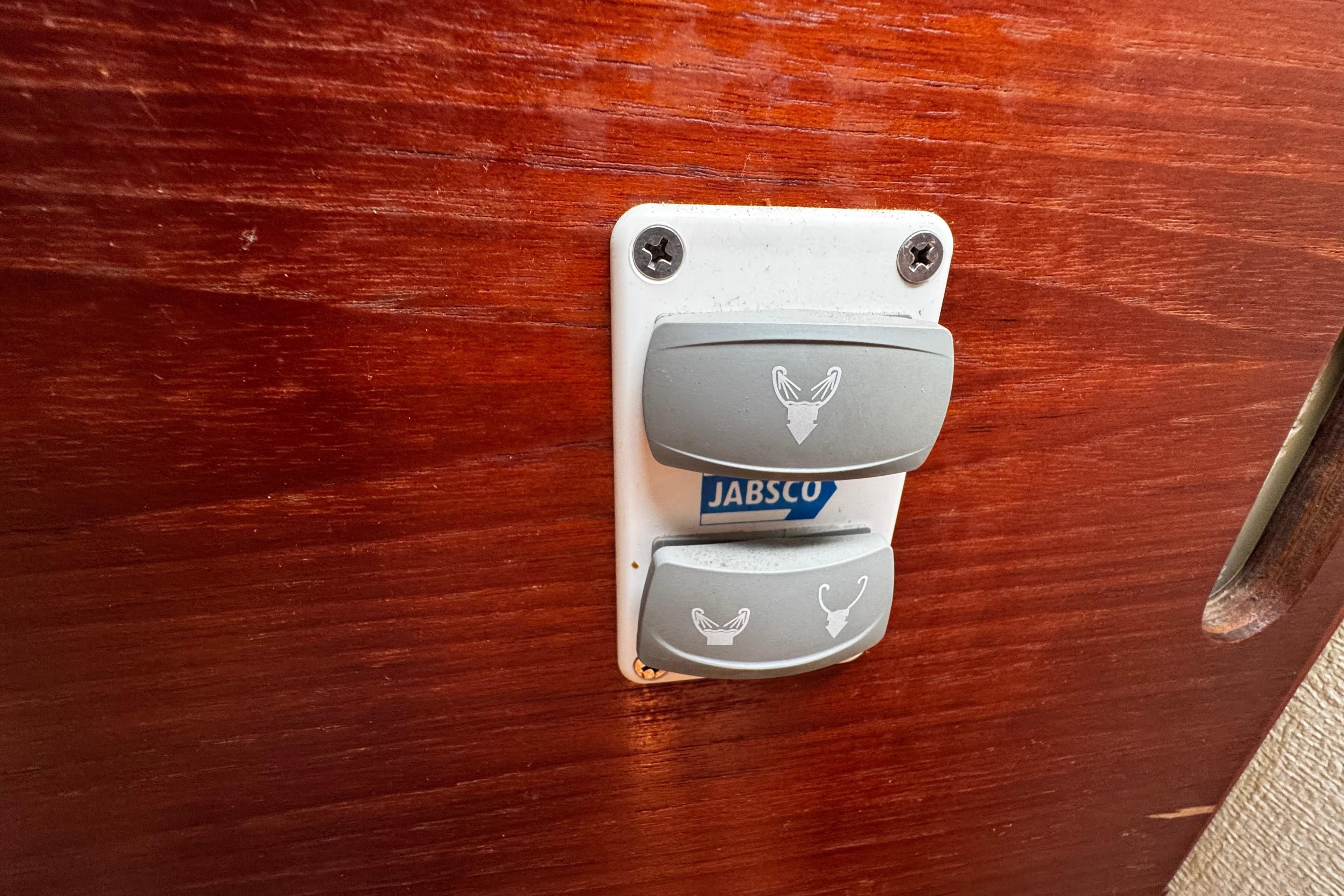 Jabsco switch panel on 1982 Pearson 323 boat with wooden background.