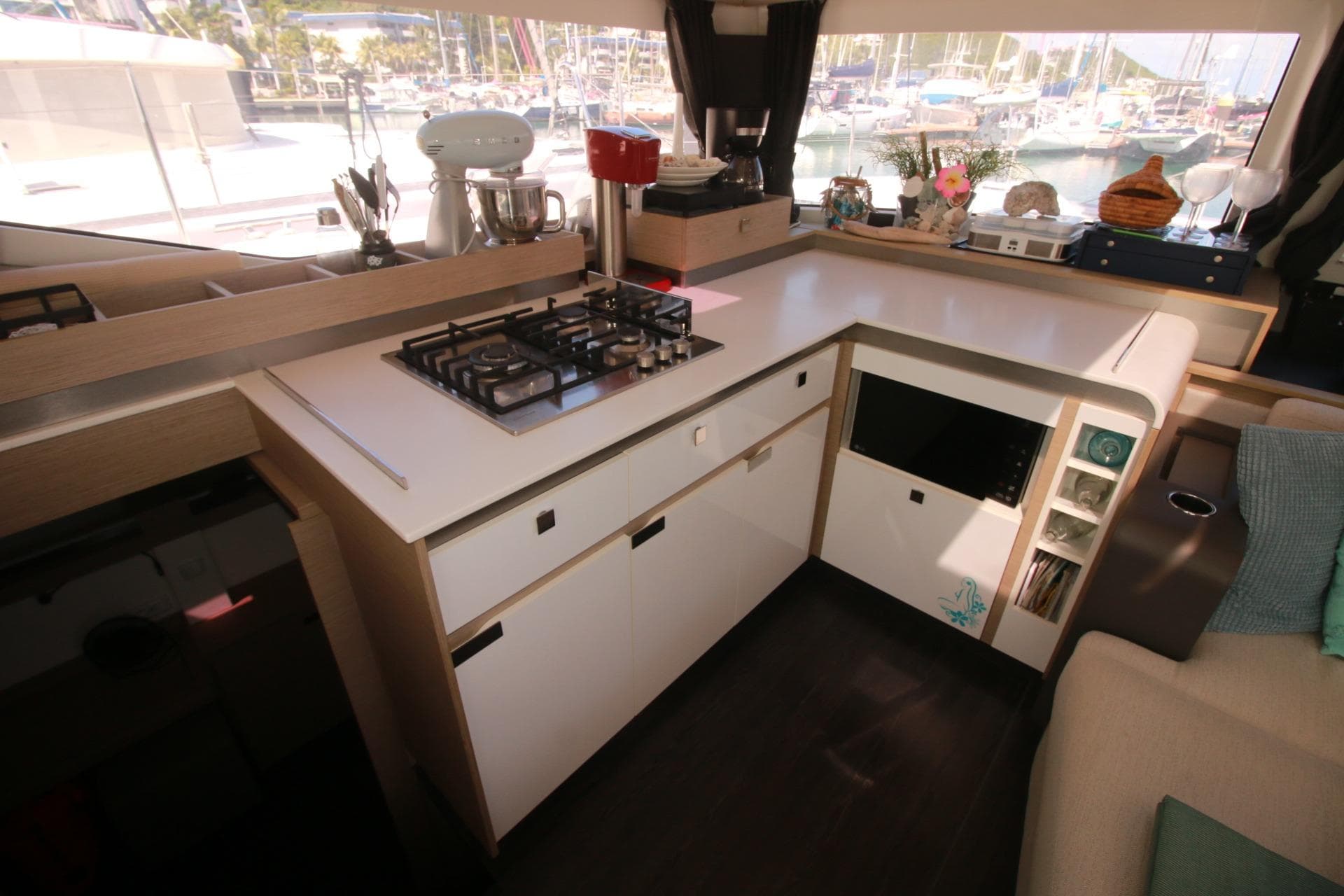 Modern kitchen interior of 2022 Fountaine Pajot Elba 45 Catamaran with appliances and marina view.
