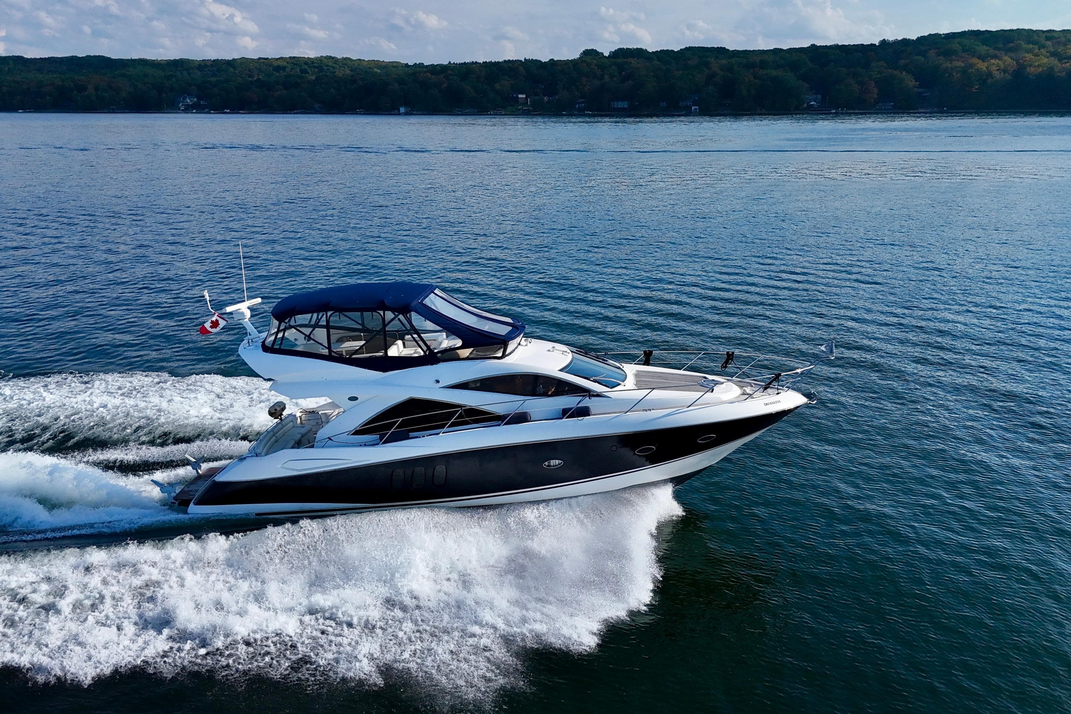 2005 Sunseeker Manhattan 50 yacht cruising on a serene lake.