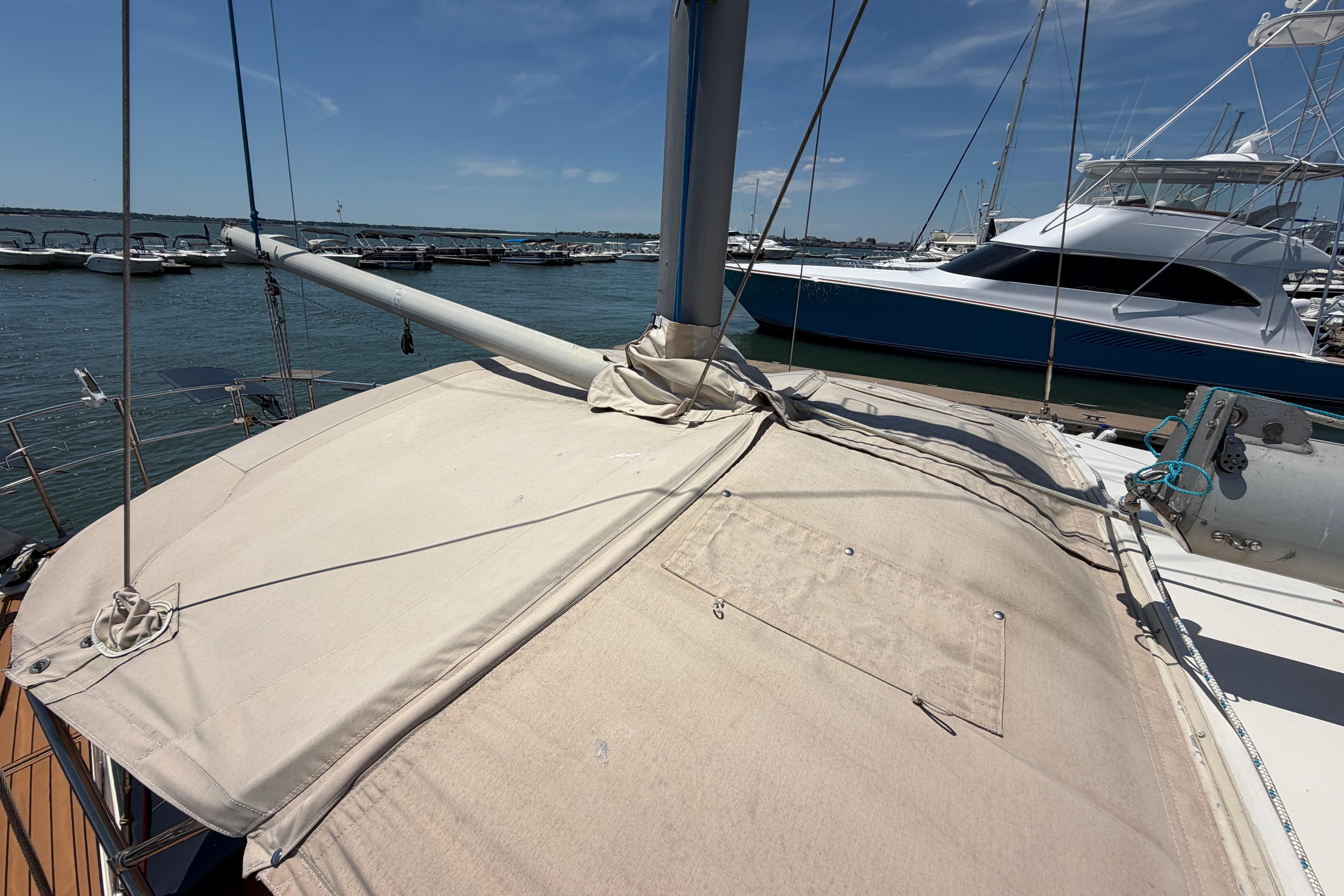 1980 Amel Mango 52 sailboat docked at marina under clear blue sky.