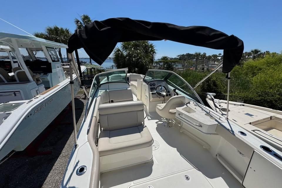 2015 Boston Whaler 230 Vantage boat with seating and canopy, docked outdoors.