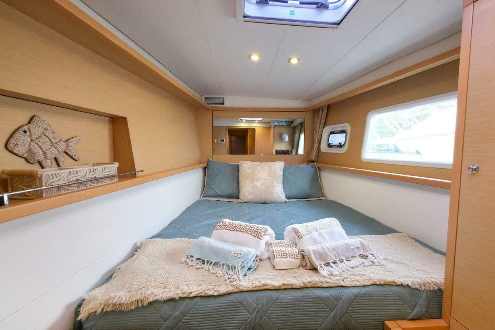 Luxurious cabin interior of 2016 Lagoon 450 catamaran with cozy bedding and decorative accents.
