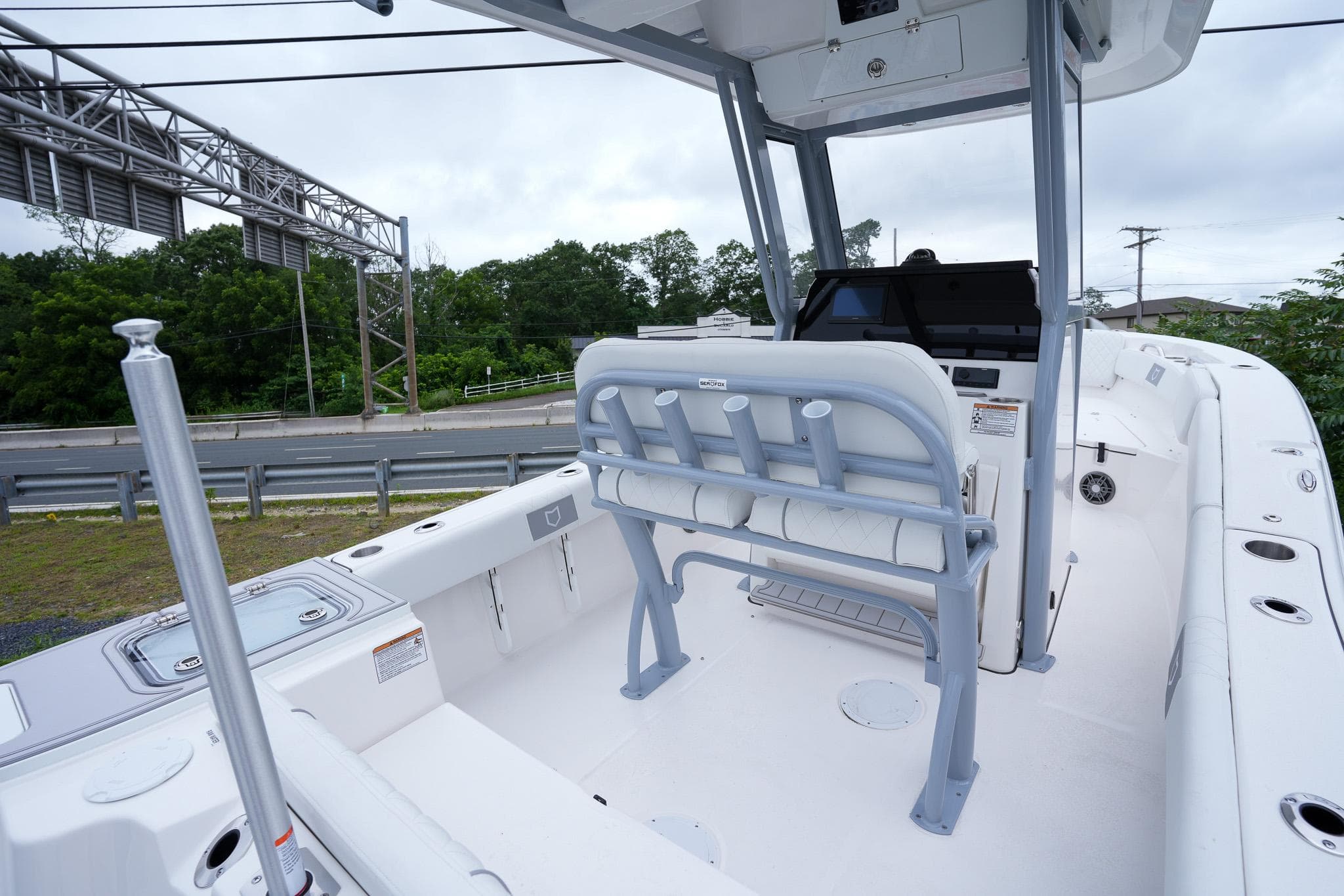 2026 Sea Fox 228 Commander boat interior with seating and console, parked near a road.