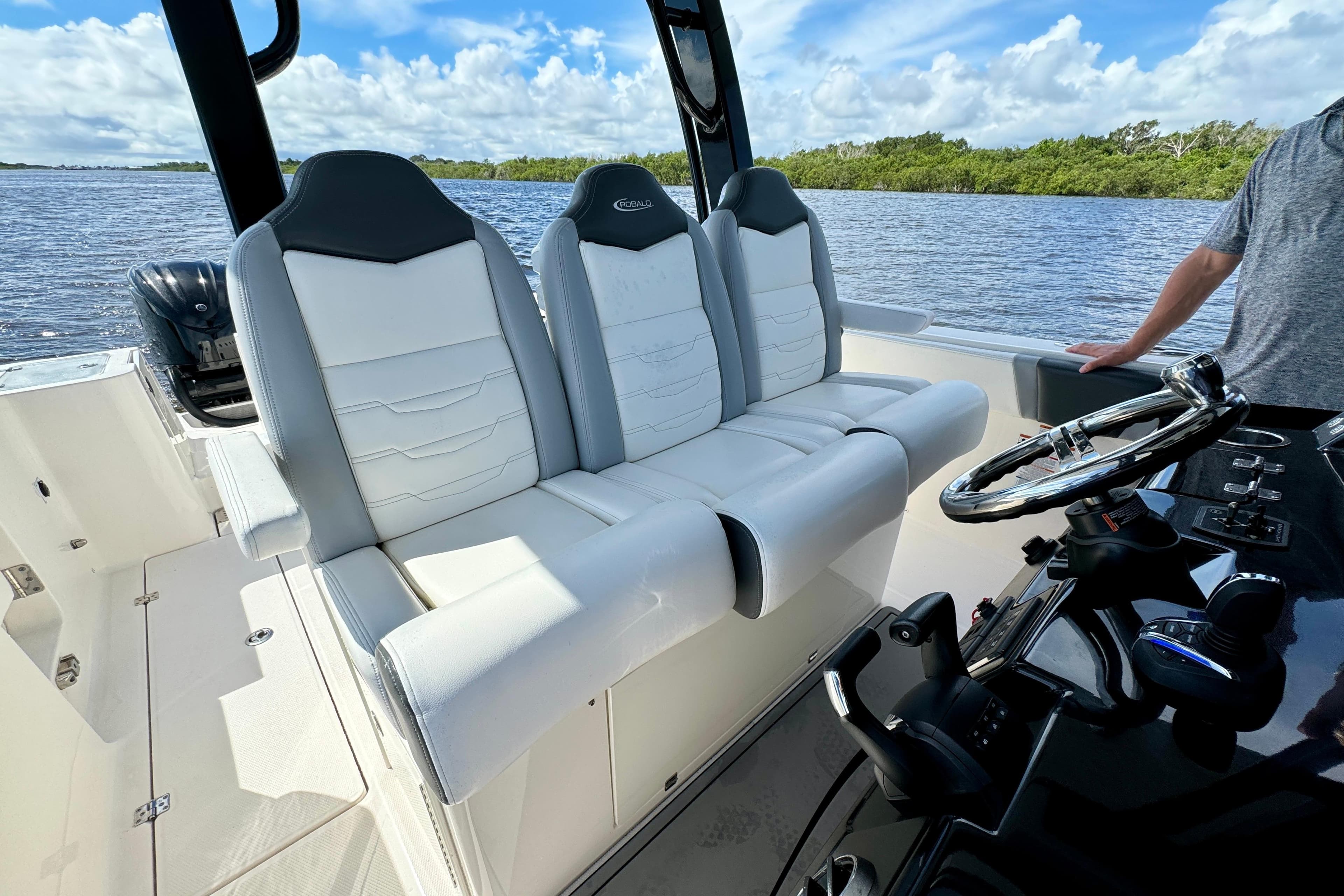2022 Robalo R360 Center Console boat interior with white seating and steering wheel.