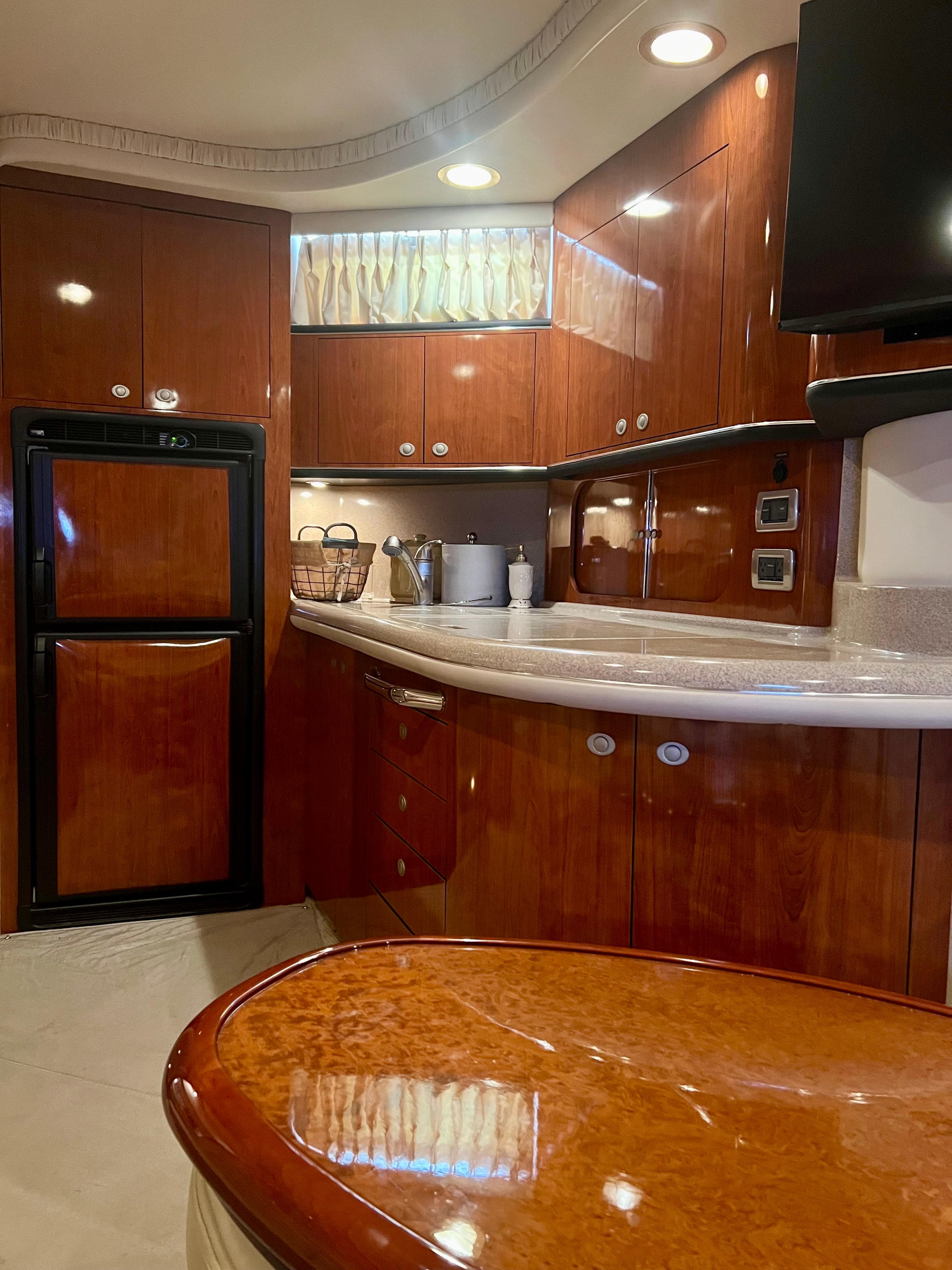 Luxurious 2004 Sea Ray 46 SUNDANCER yacht interior with polished wood cabinetry and modern amenities.