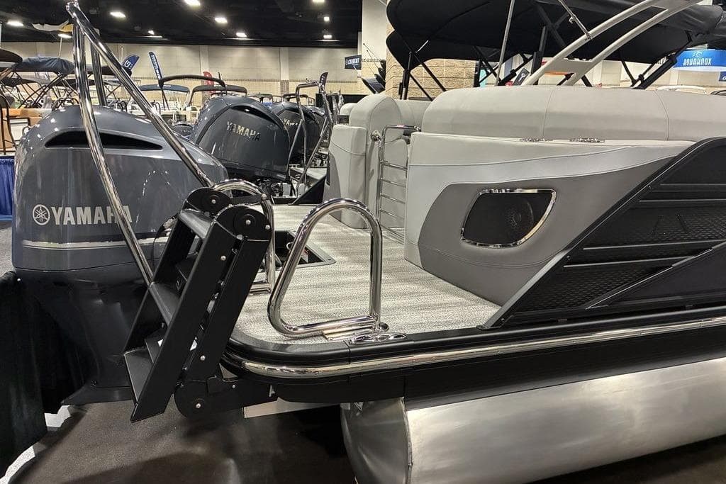 2025 Bennington LX Sport Quad Bench 24 LXSFBA pontoon boat with Yamaha engine at a boat show.