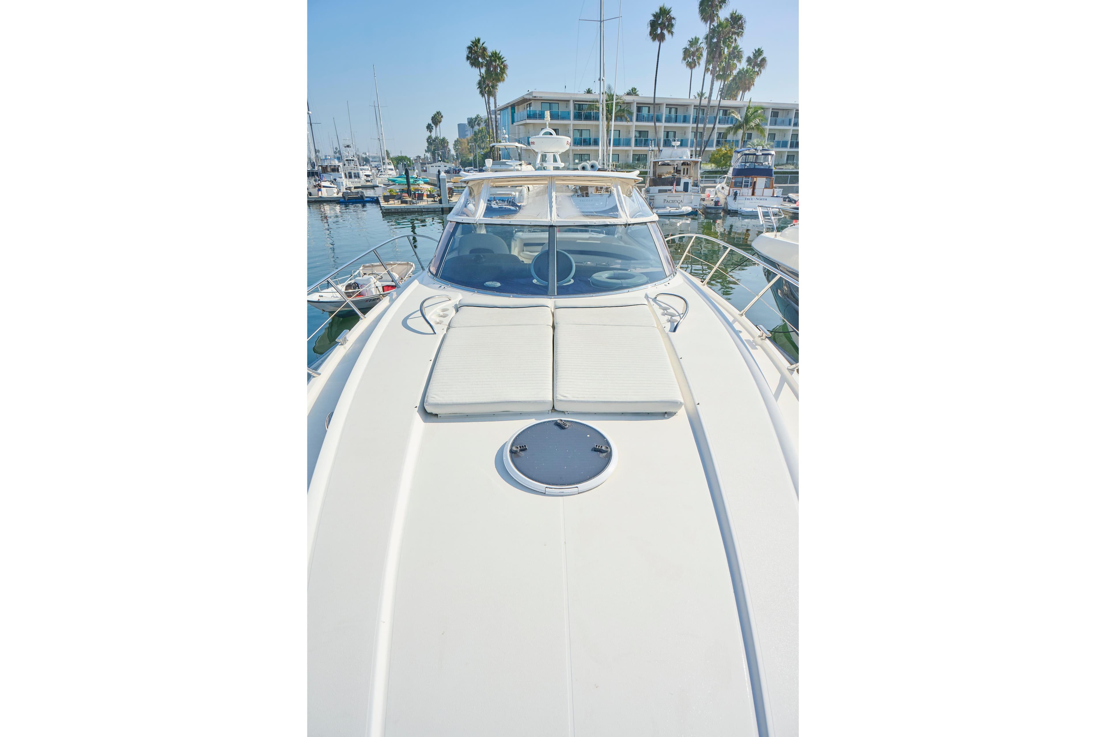 Sunseeker Camargue 50 yacht, 2000 model, docked in a marina with palm trees.