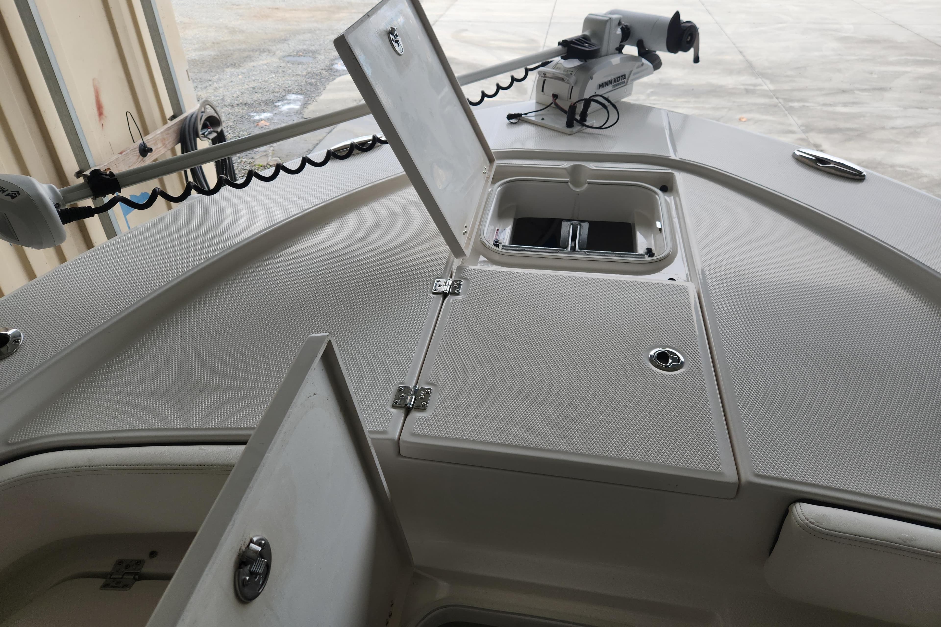 2024 Robalo 246 Cayman boat deck with open storage compartments and trolling motor.