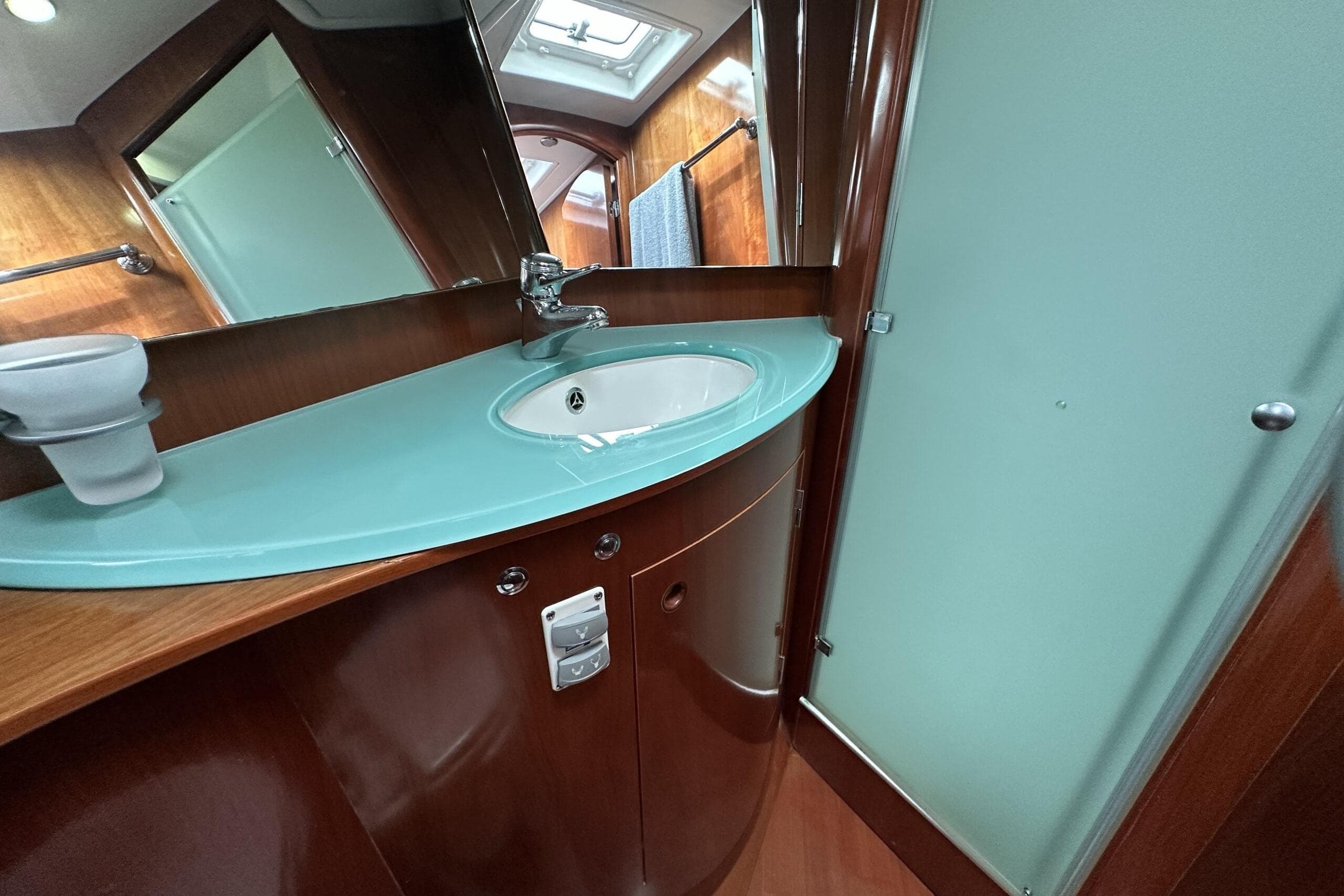 Luxurious bathroom interior of 2003 Beneteau 57 yacht with modern sink and mirror.