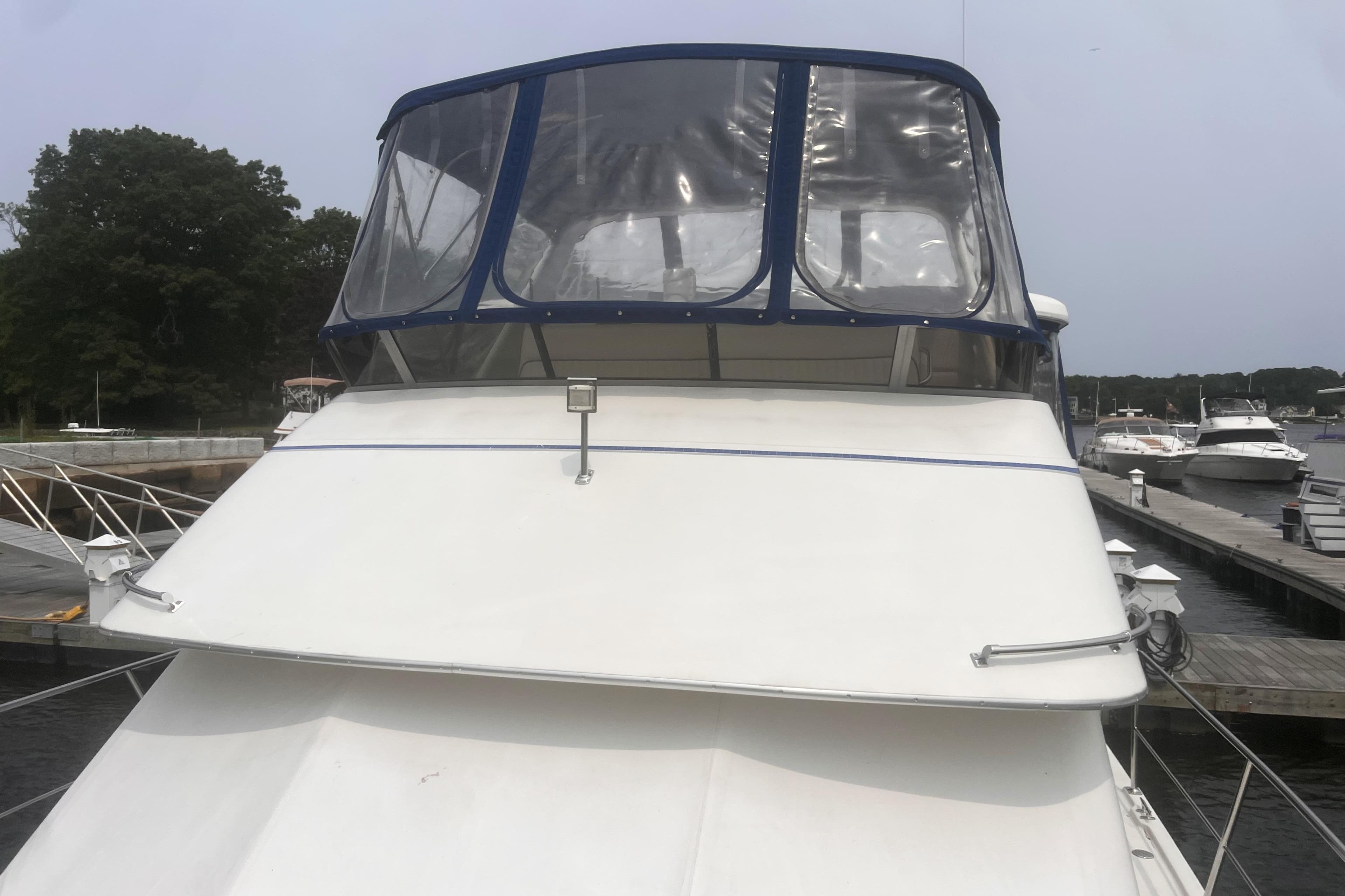 1994 Carver 350 yacht docked at marina, featuring a clear canopy and sleek design.