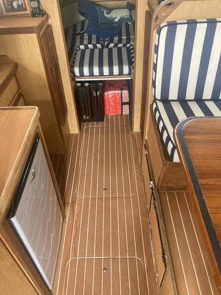 Interior of 1987 Bertram 28 Sport Fisherman with striped seating and wooden flooring.