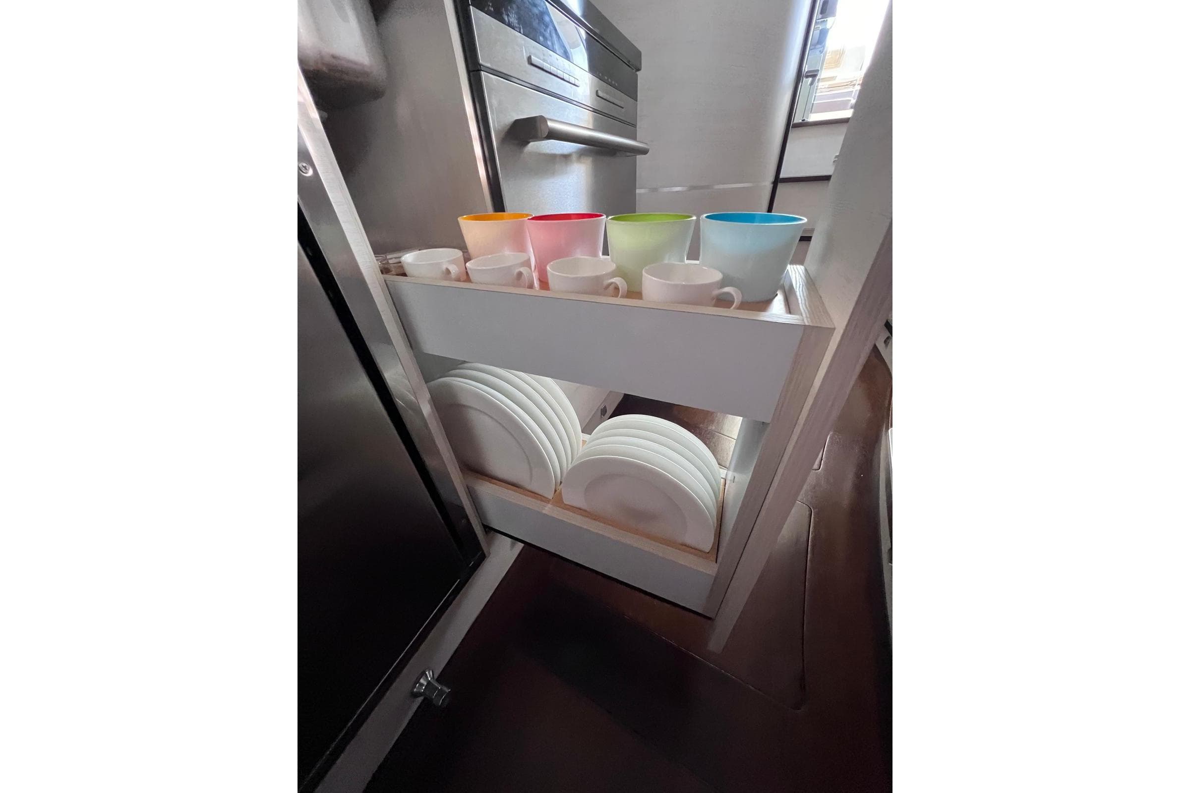 Kitchen storage with colorful cups and plates on Solemar 44.1 Oceanic yacht, 2014 model.
