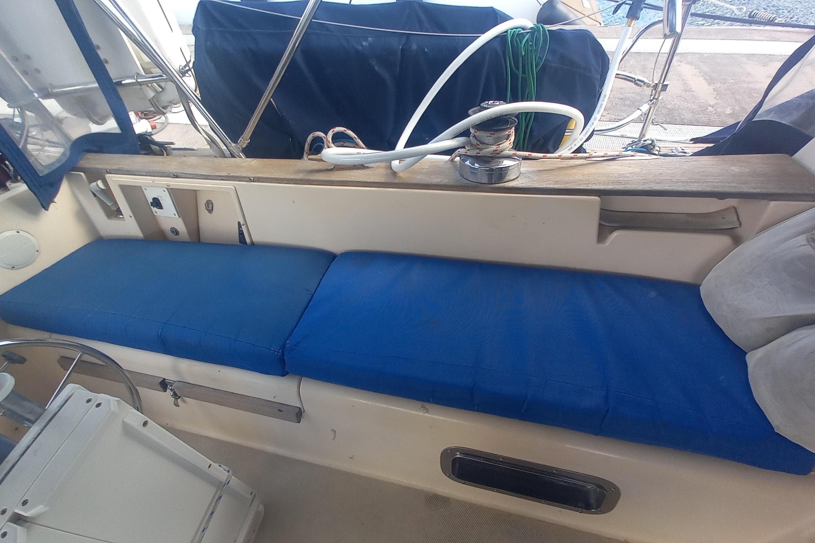 Interior view of a 1993 Island Packet 38 sailboat with blue seating cushions.