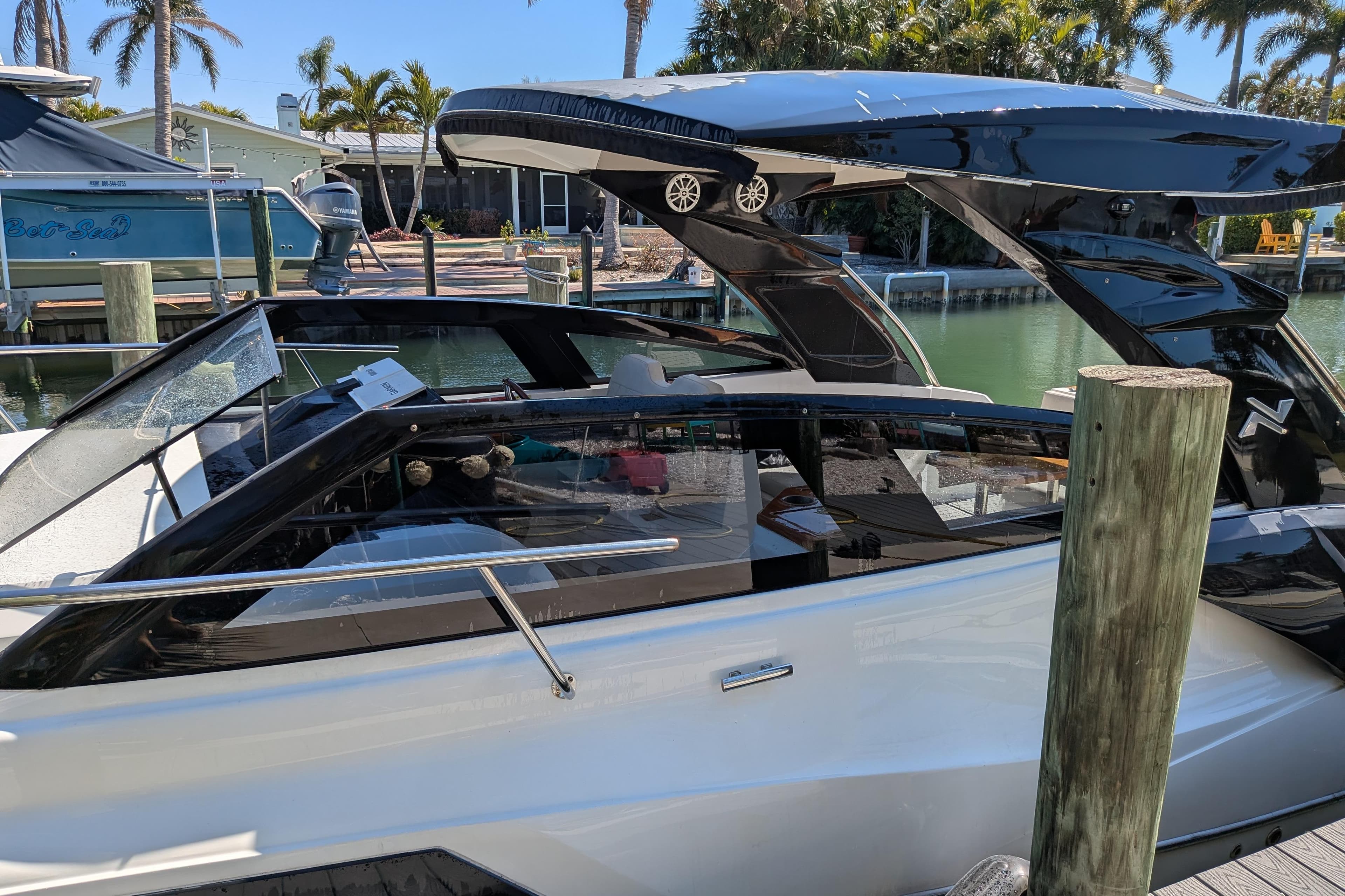 2023 NX Boats 340 Sport Coupe docked by a waterfront, showcasing sleek design.
