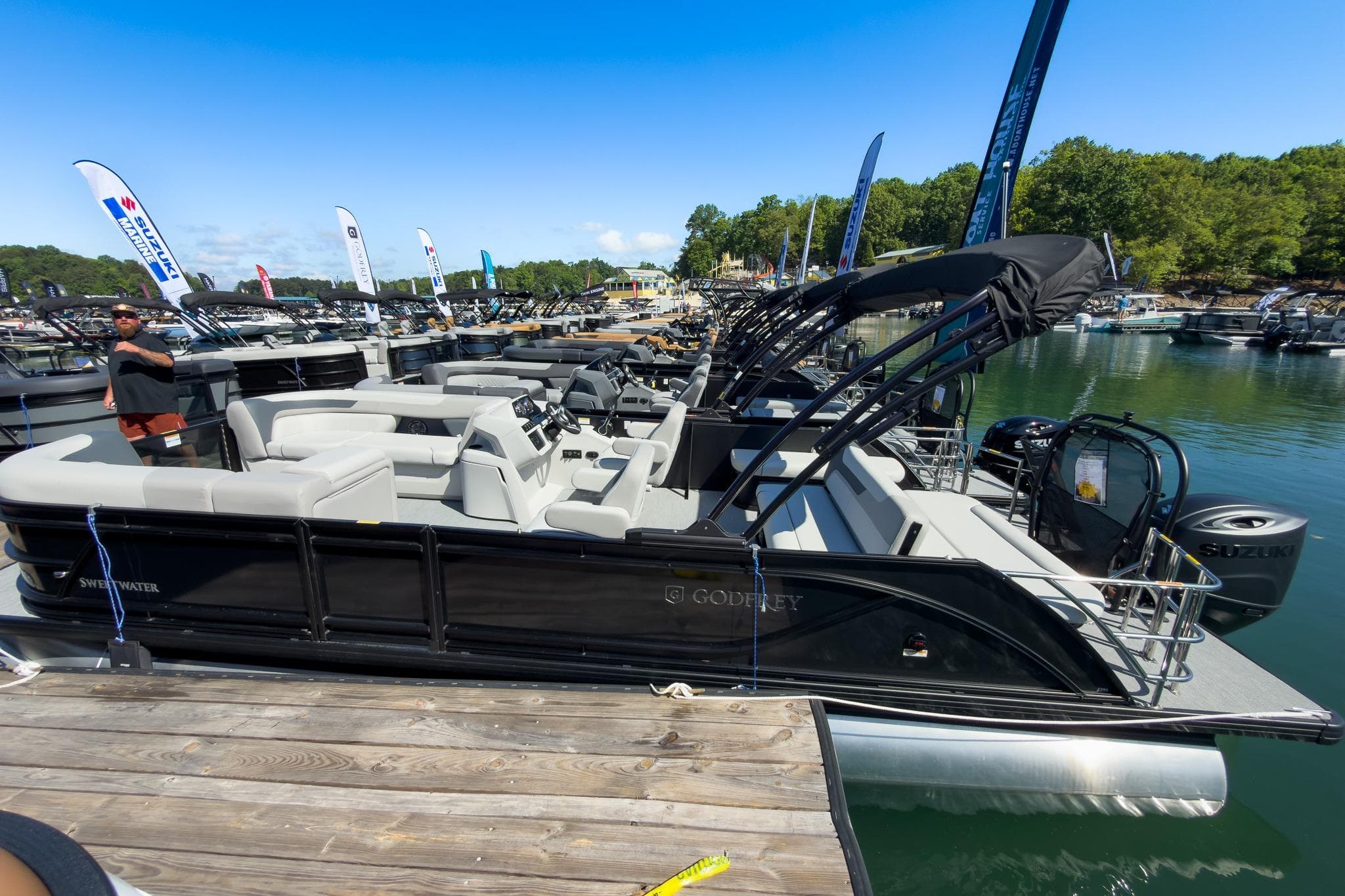 2026 Godfrey Sweetwater 22' Tritoon docked, showcasing sleek design and spacious seating.