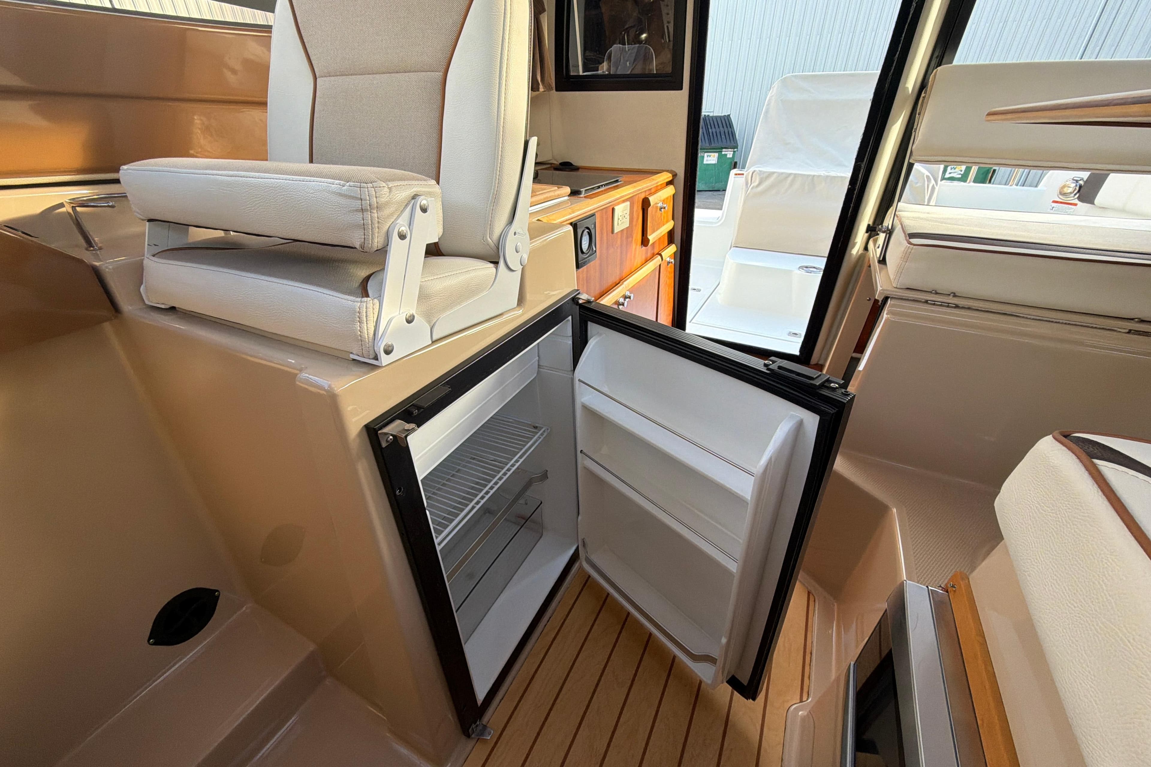 2016 Cutwater C-242 Coupe interior with open fridge and seating.