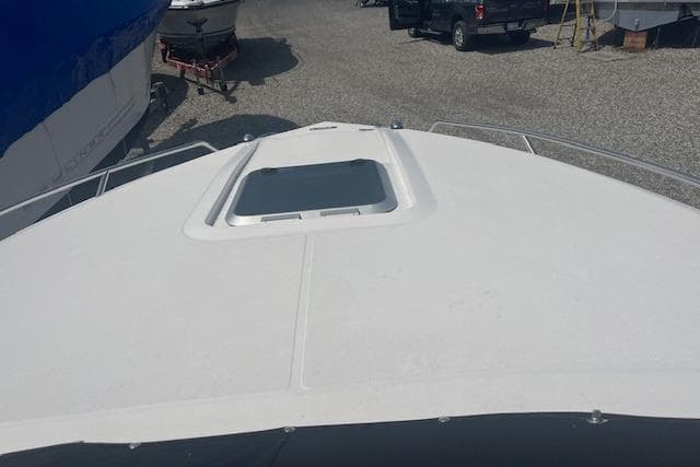 2015 Rinker 276 Captiva Cuddy boat deck with hatch, parked outdoors.
