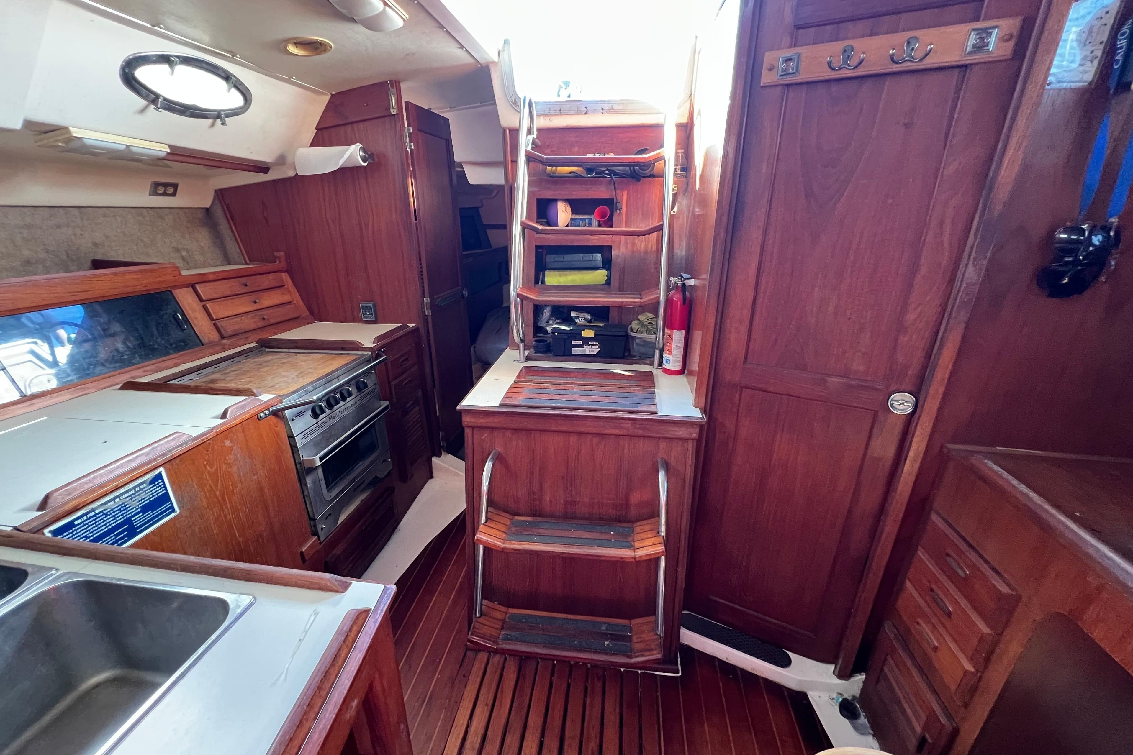 Interior of 1986 Hunter Legend 45 sailboat with wooden cabinetry and kitchen area.