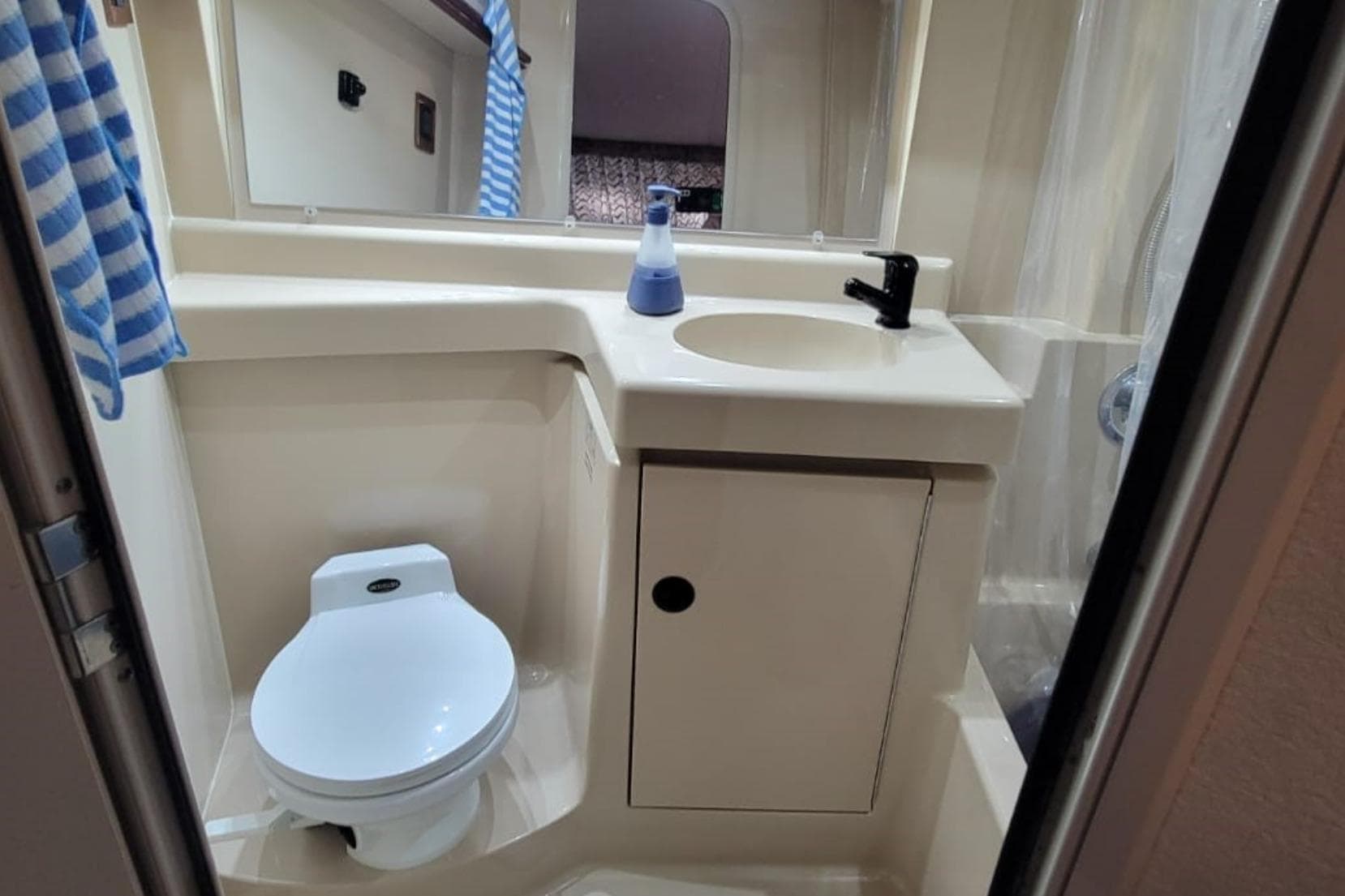 1999 Cruisers Yachts 3750 Motoryacht bathroom with toilet, sink, and mirror.