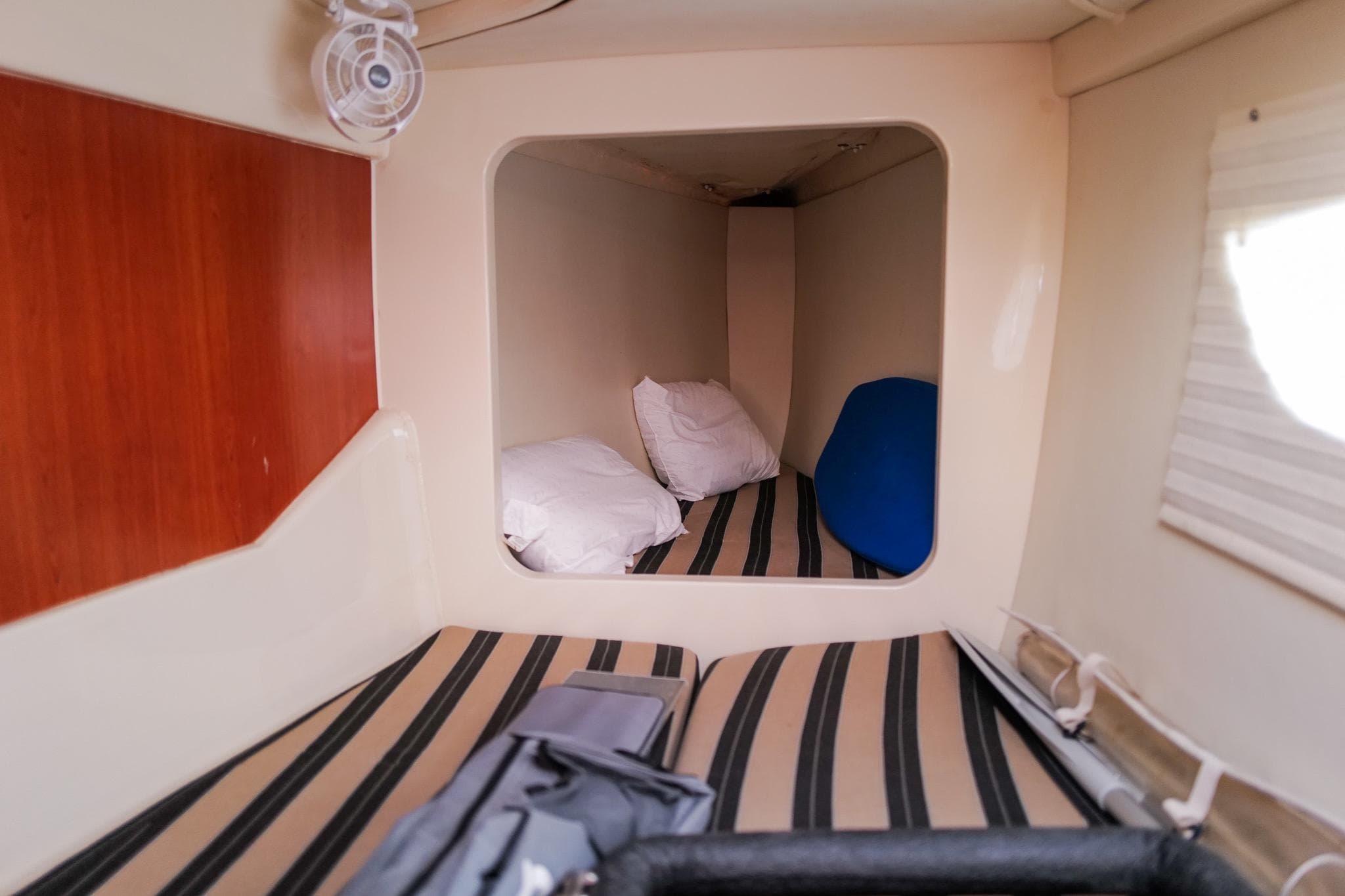 Cozy cabin interior of 2012 Leopard 44 yacht with striped bedding and pillows.