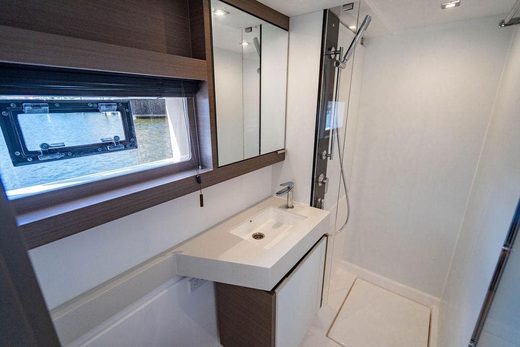 Modern bathroom on 2022 Leopard 53 Powercat yacht with sleek fixtures and window view.