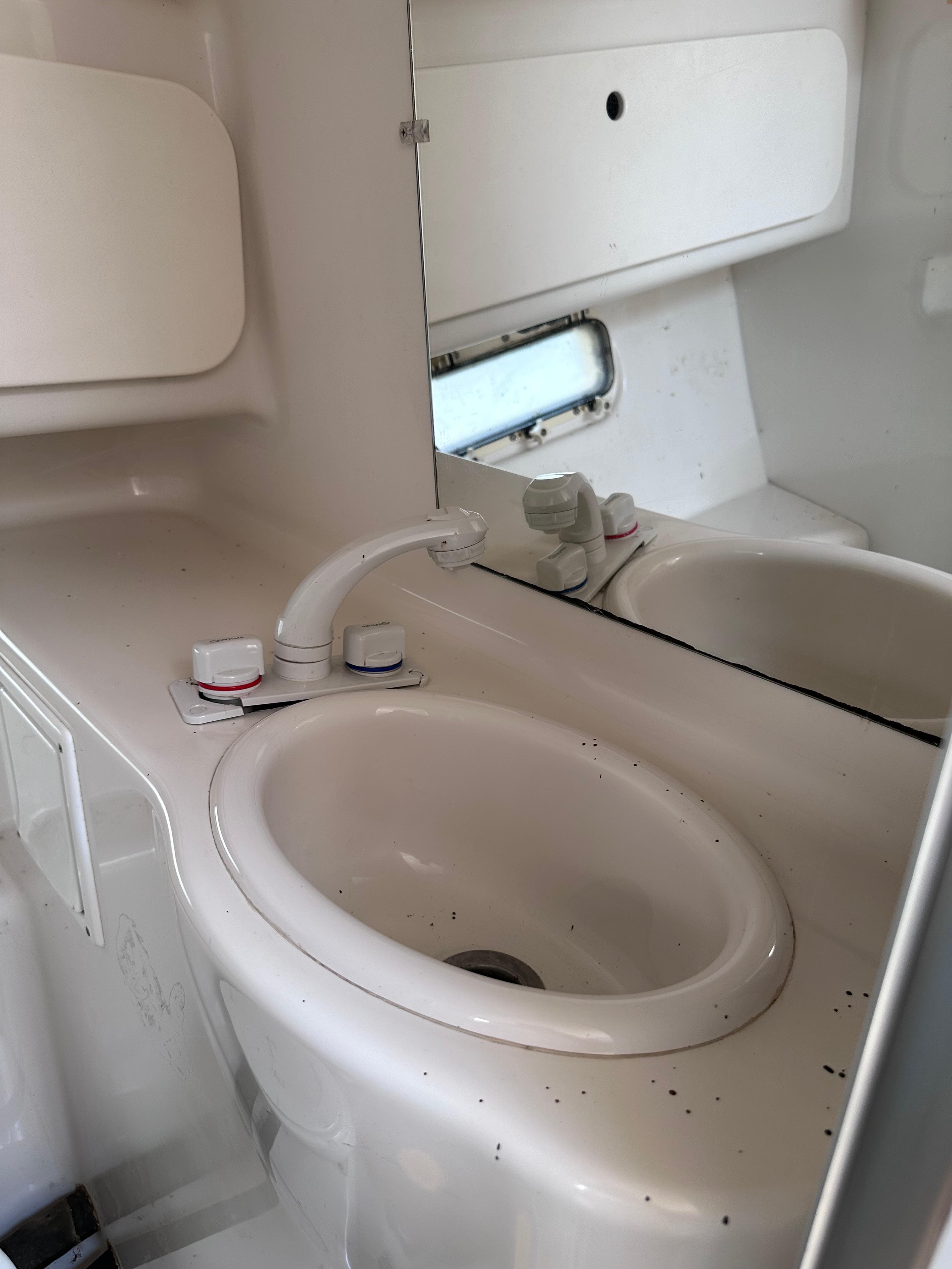 1996 Maxum 2400 SCR boat bathroom sink with mirror and faucet.