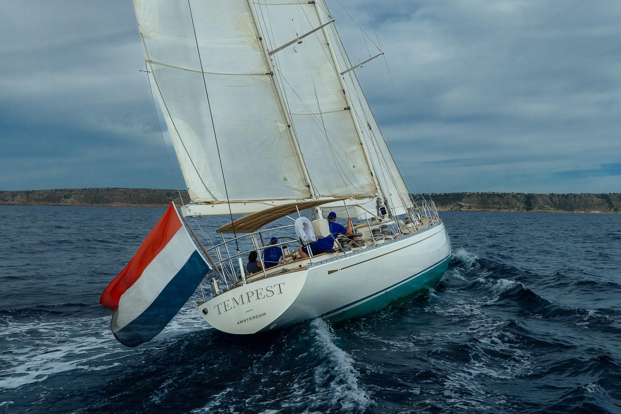 1974 Palmer Johnson sailing yacht "Tempest" navigating open sea with Dutch flag.