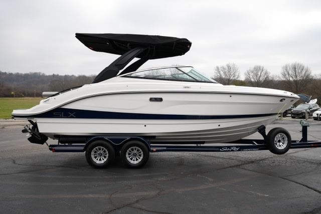 2026 Sea Ray SLX 260 boat on trailer, white with black canopy, parked outdoors.