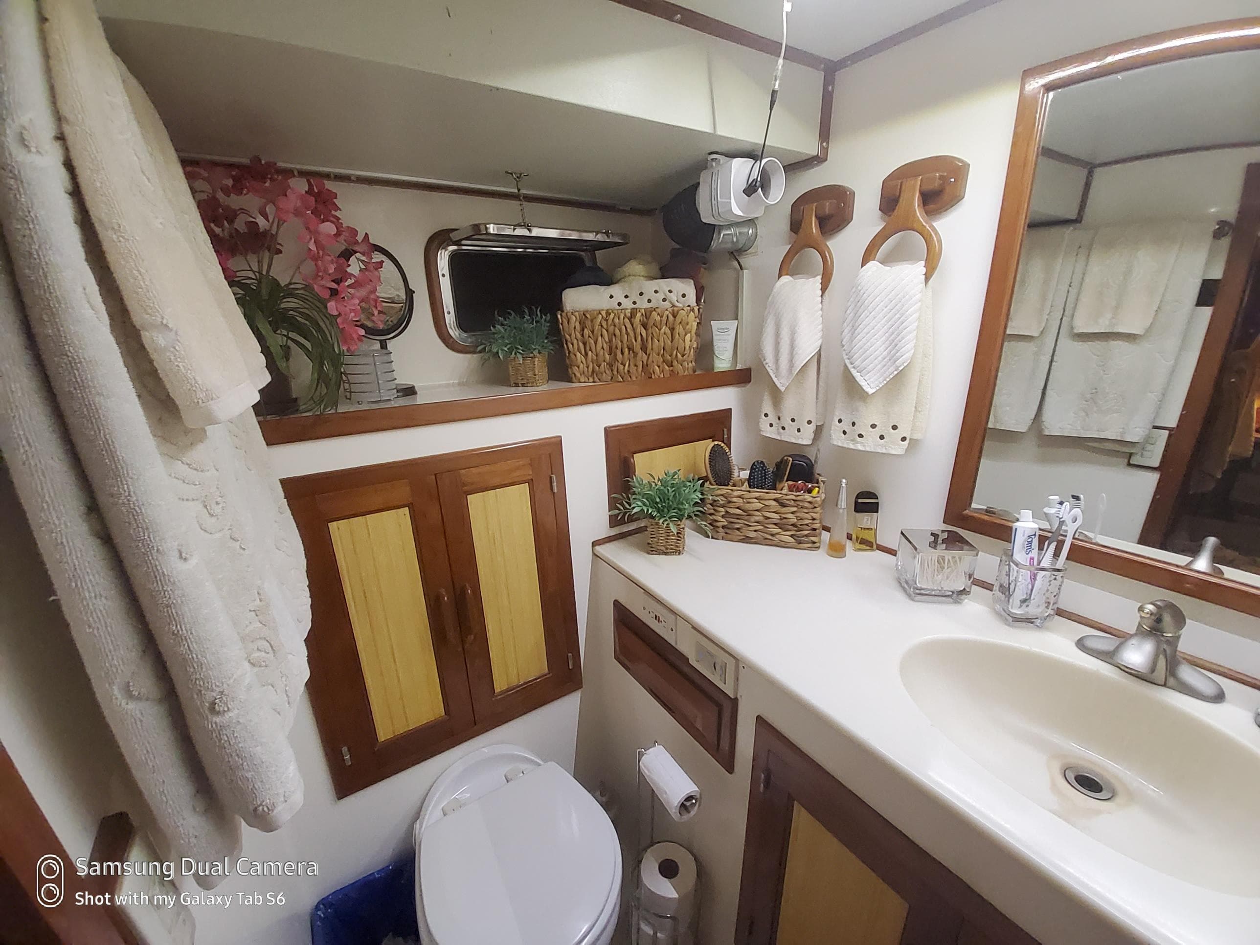 Bathroom interior of 1989 DeFever 57 POC Motor Yacht, featuring sink, mirror, and decor.