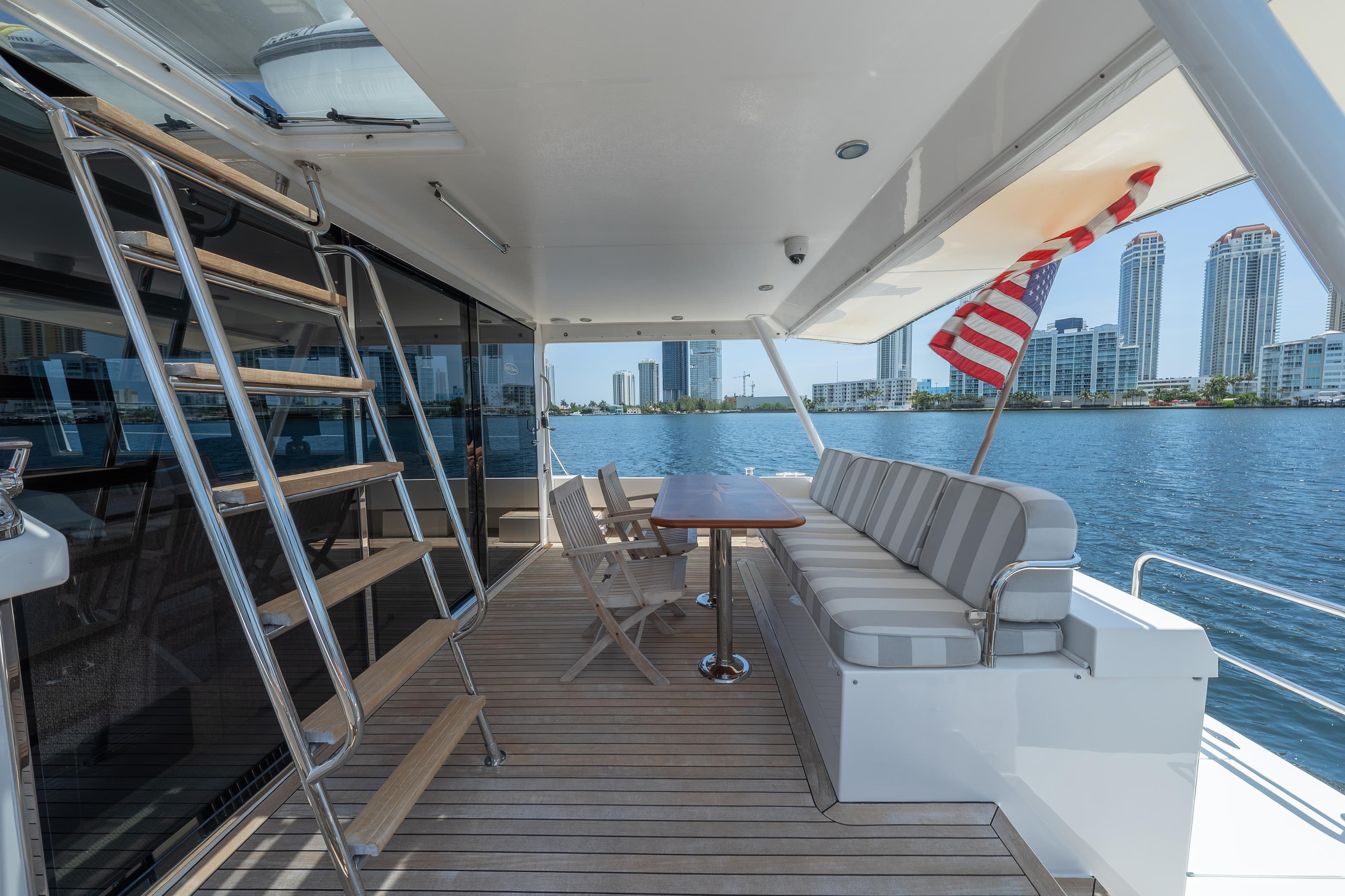 2007 Pacific Mariner Pilothouse yacht deck with seating, table, and city skyline view.