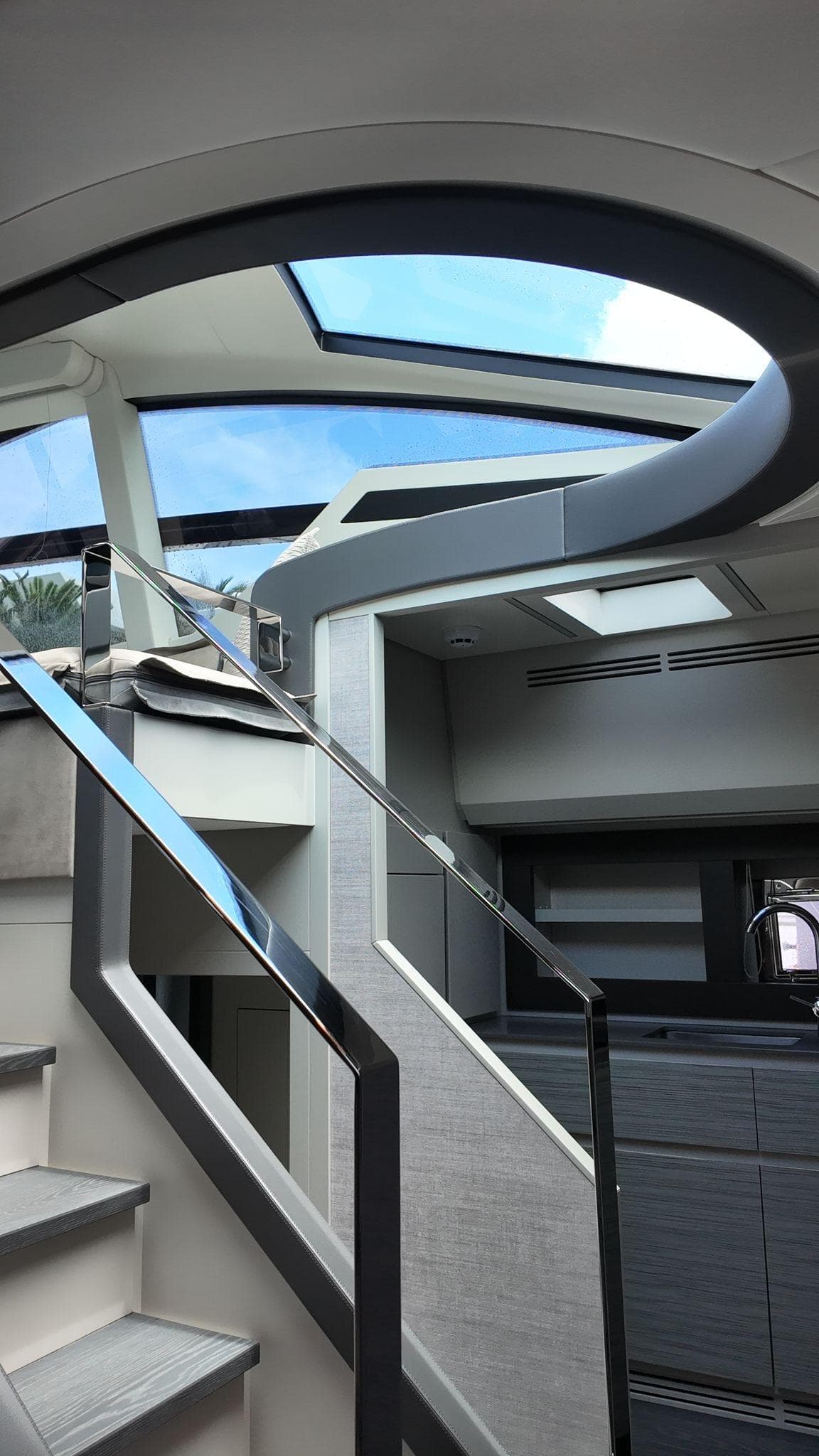 Interior view of 2022 Pershing 6X yacht with modern staircase and skylight.