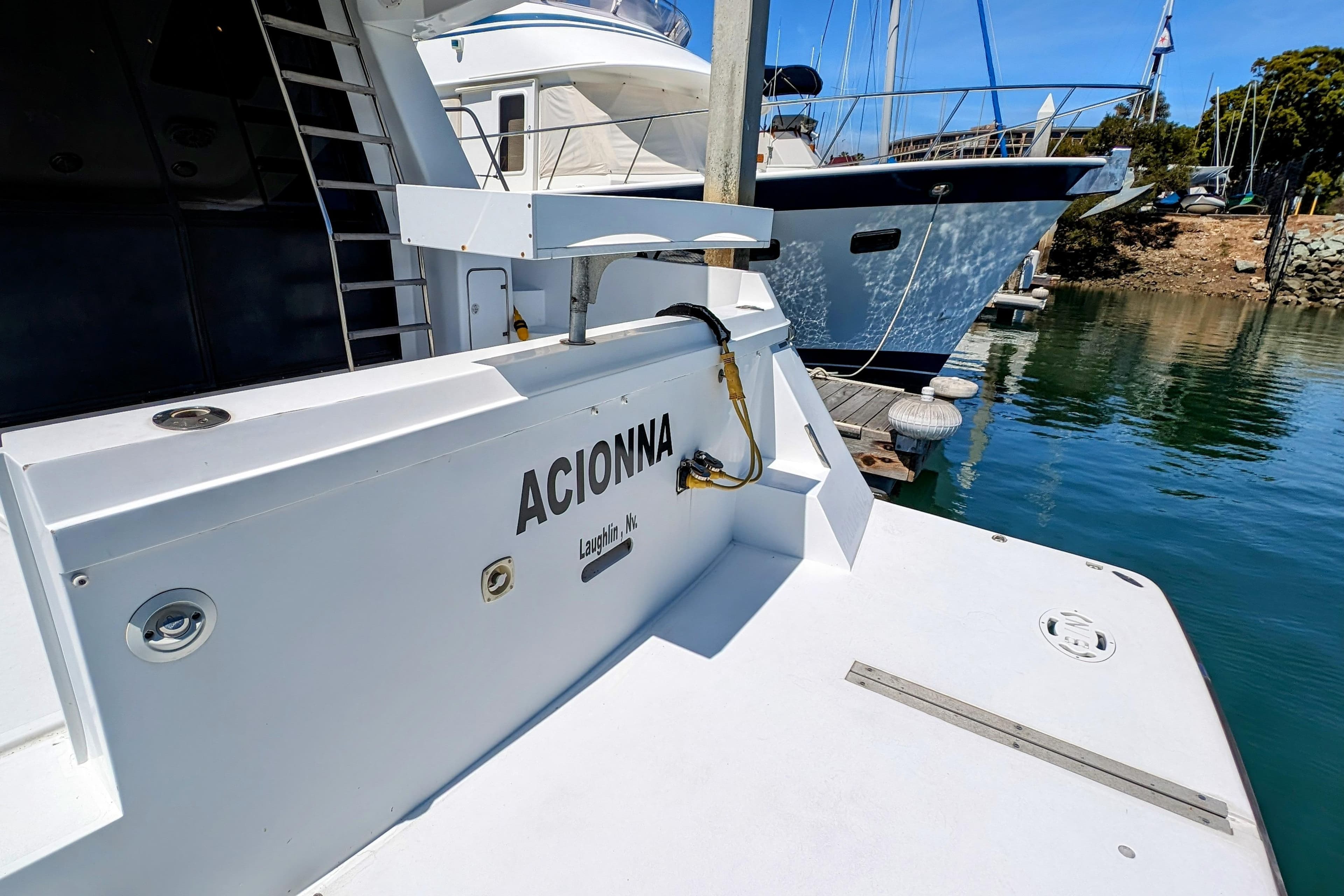 1990 Neptunus Sedan 148 yacht docked at marina, featuring "ACIONNA" name on stern.
