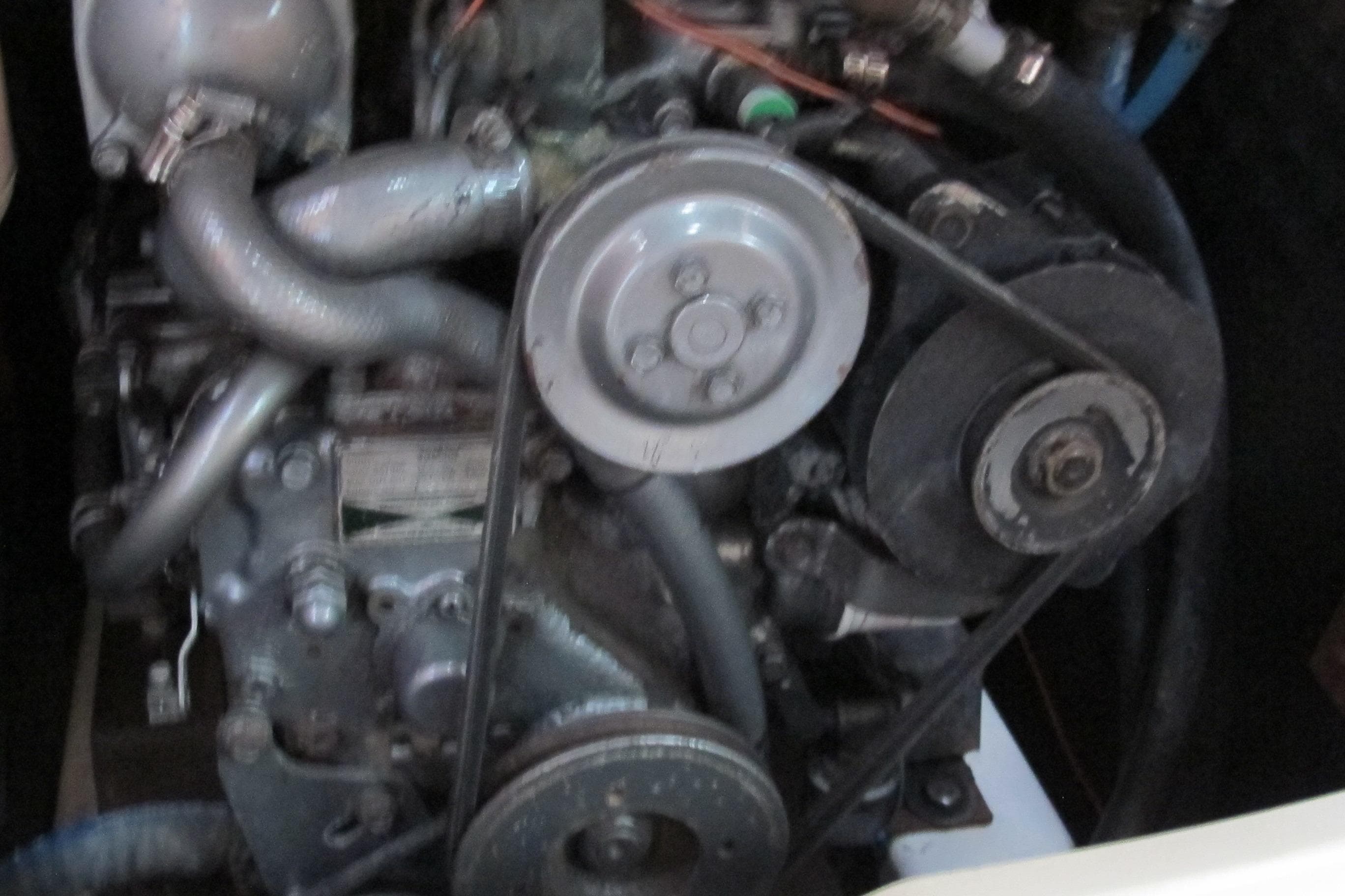 Engine of a 2000 Beneteau Oceanis 361 sailboat, showing belts and pulleys.