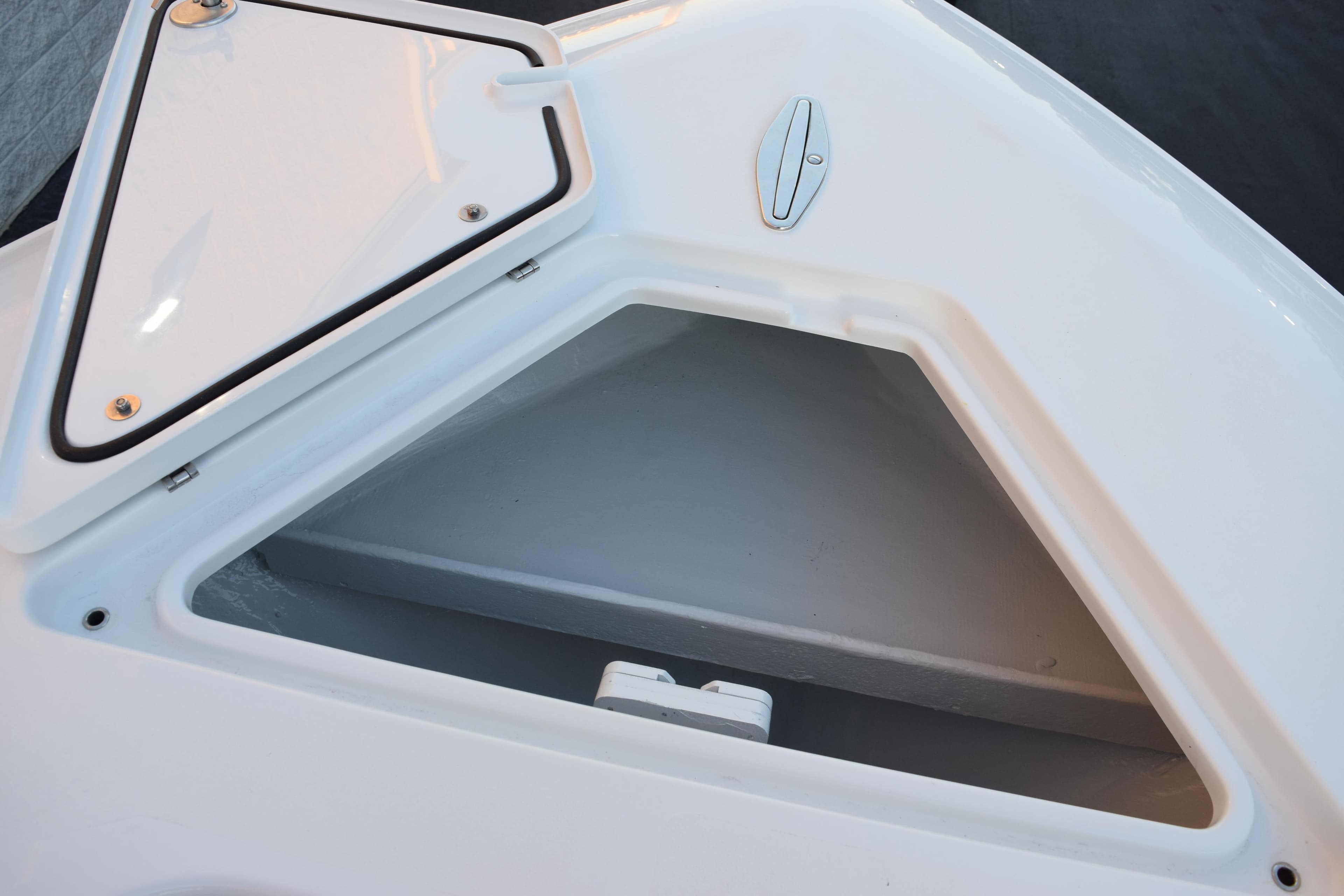 Open storage compartment on 2026 Contender 32 ST boat, featuring a triangular hatch.
