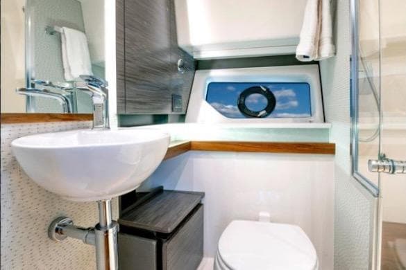 2022 Tiara Sport 43 LE yacht bathroom with modern sink, toilet, and window view.