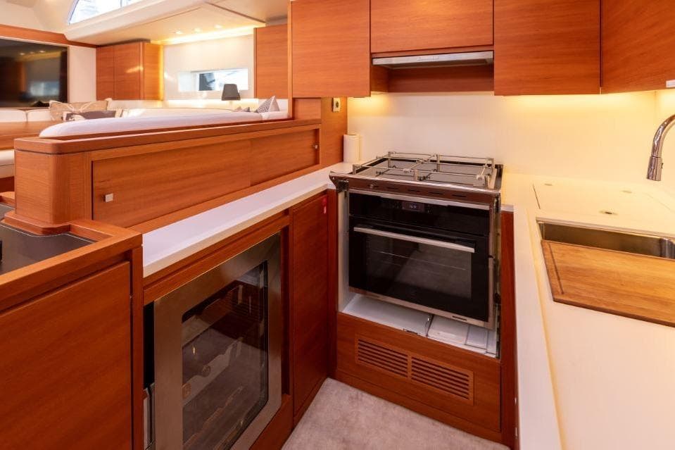 Luxurious kitchen interior of 2022 Solaris 64RS yacht with modern appliances and wood finish.