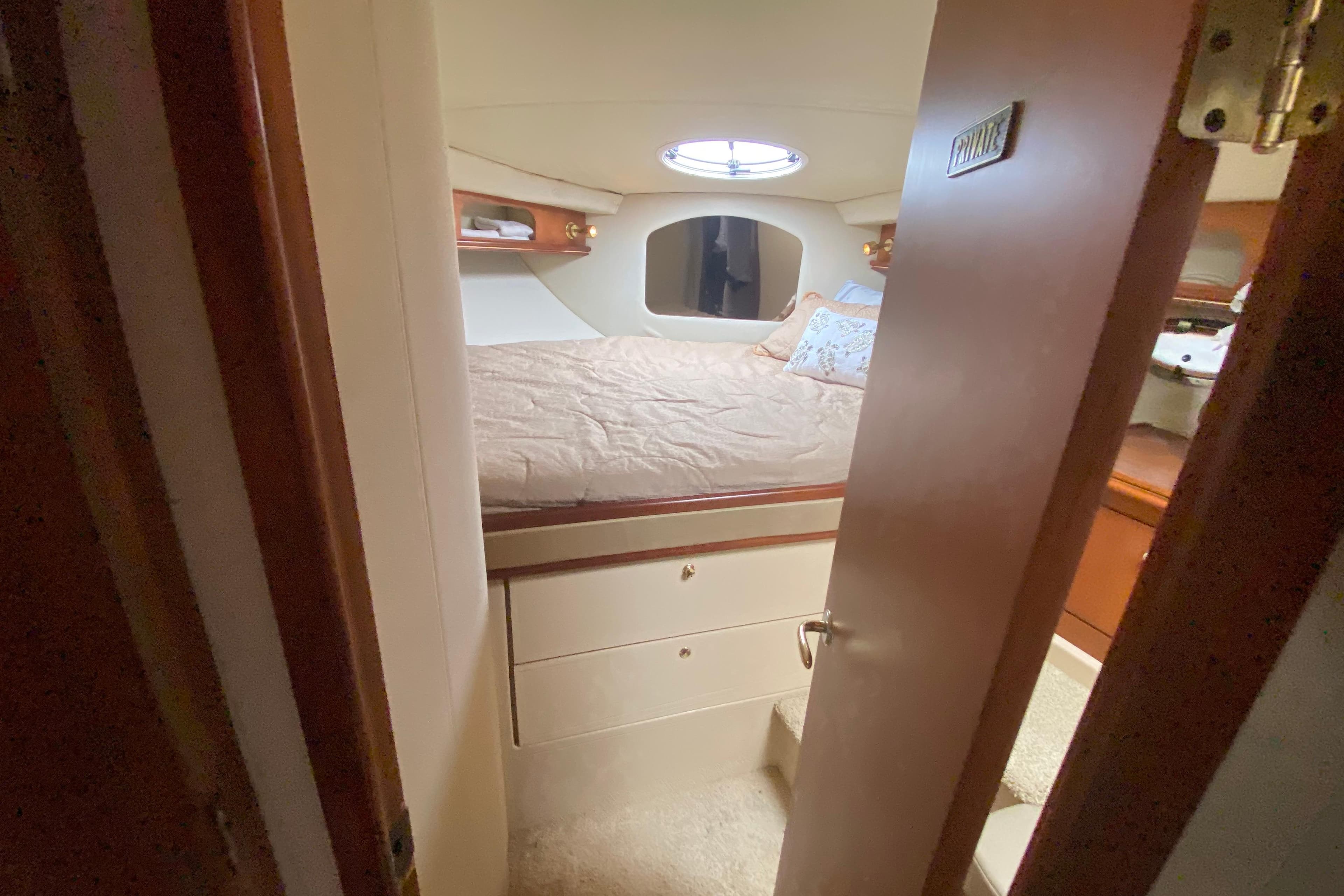 Cozy cabin interior of 2002 Cruisers Yachts 3572 Express with bed and storage.