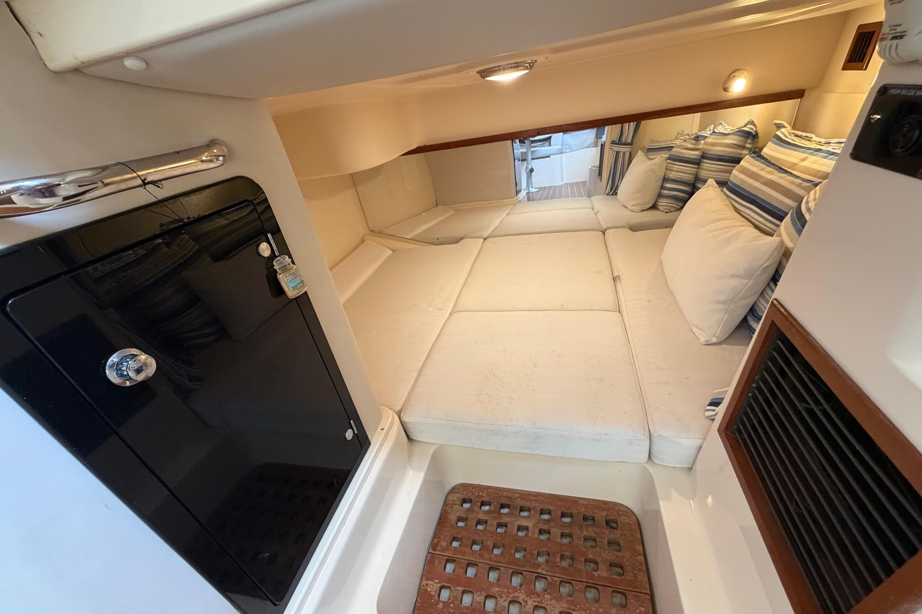 2014 Grady-White Express 330 cabin interior with cozy seating and striped cushions.
