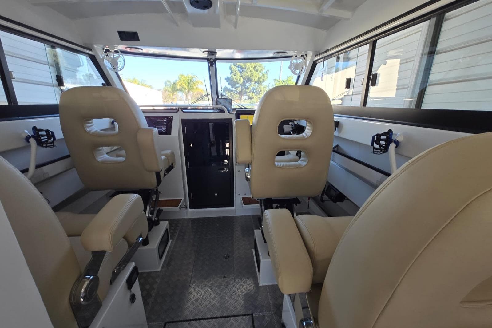 Interior of 2025 Custom Boat 34, featuring beige seating and modern controls.