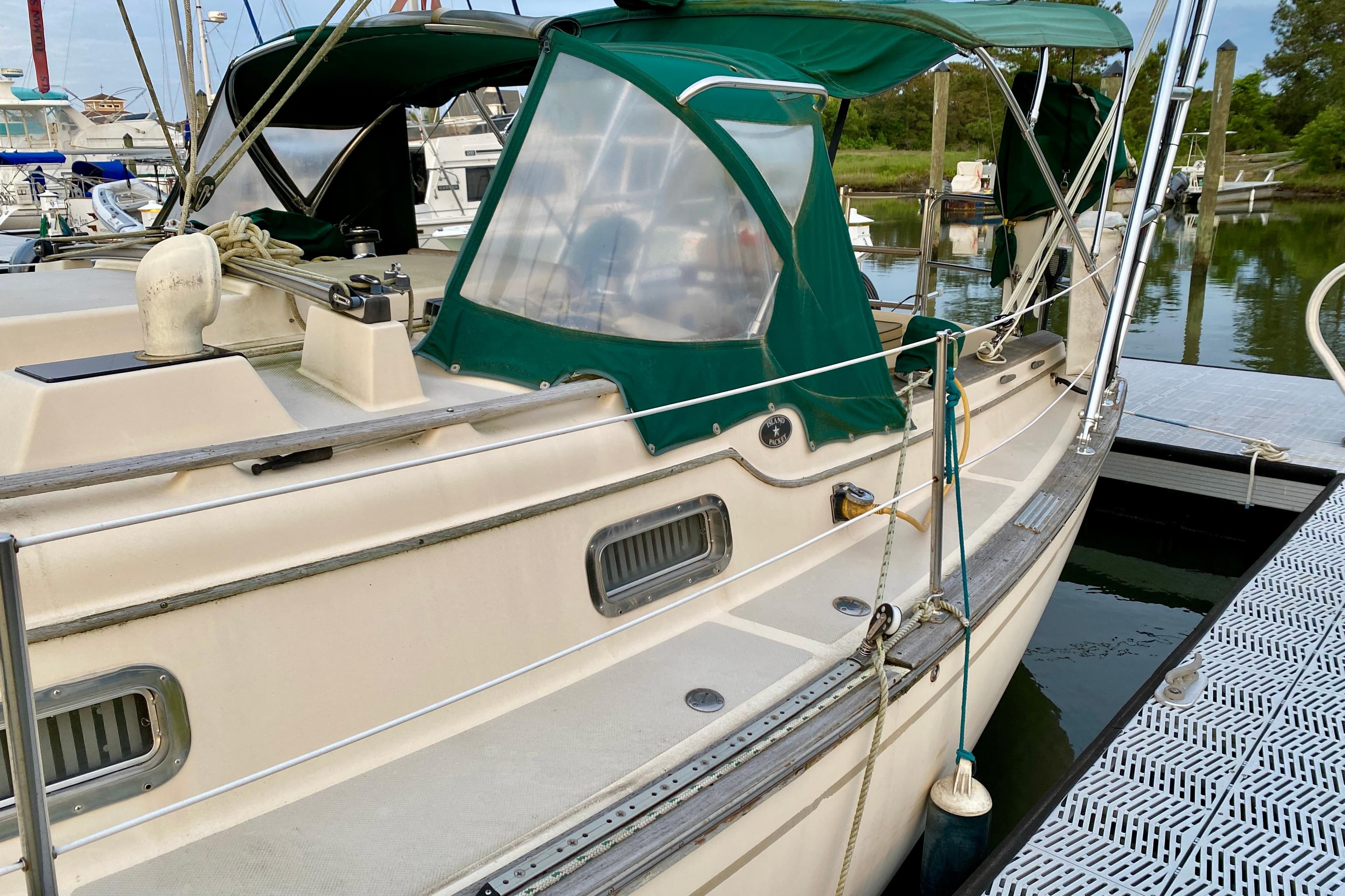 1992 Island Packet 29 sailboat docked with green canopy and clean deck.