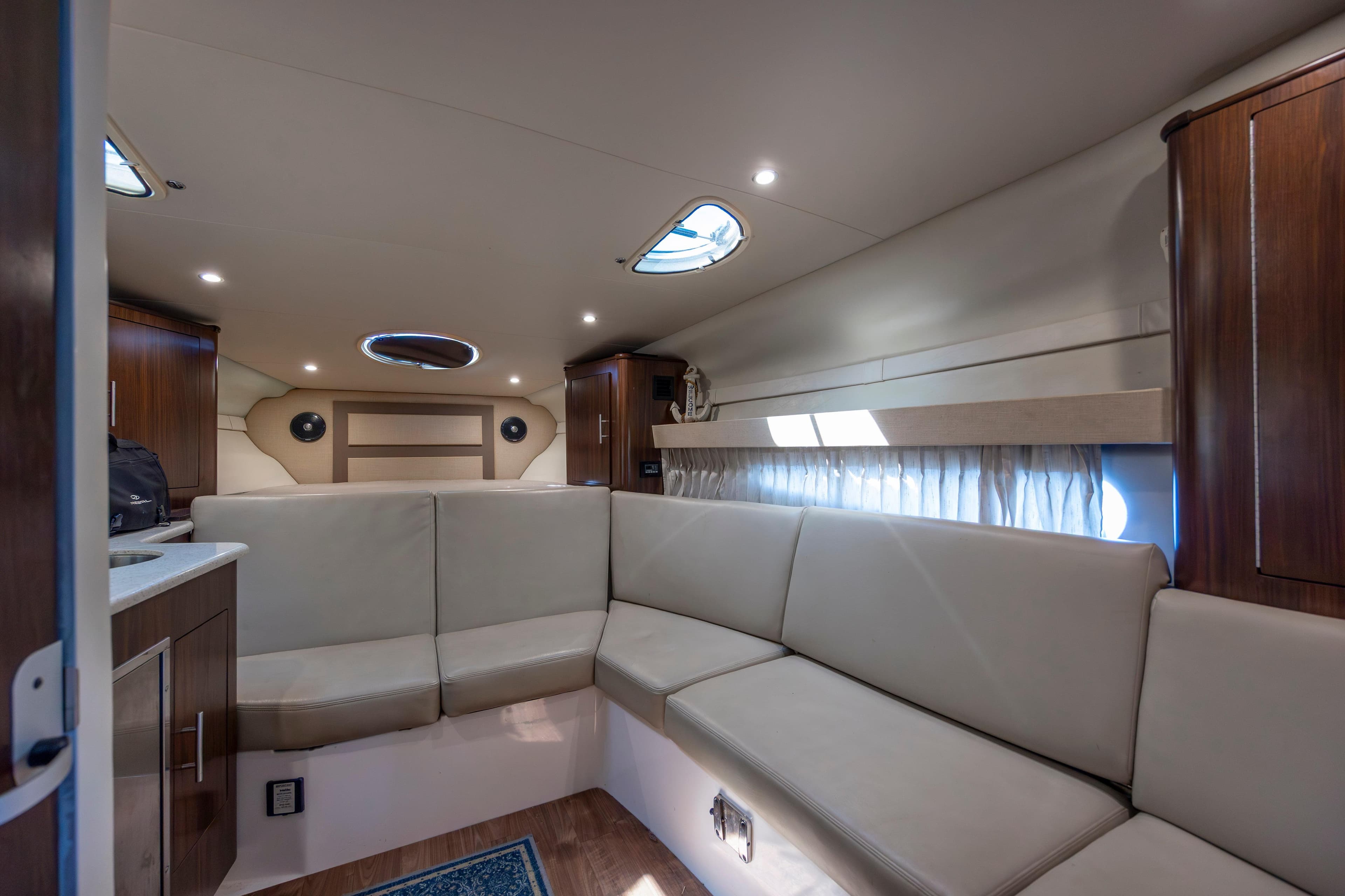 Interior of 2017 Regal 32 Express yacht with beige seating and wooden cabinets.